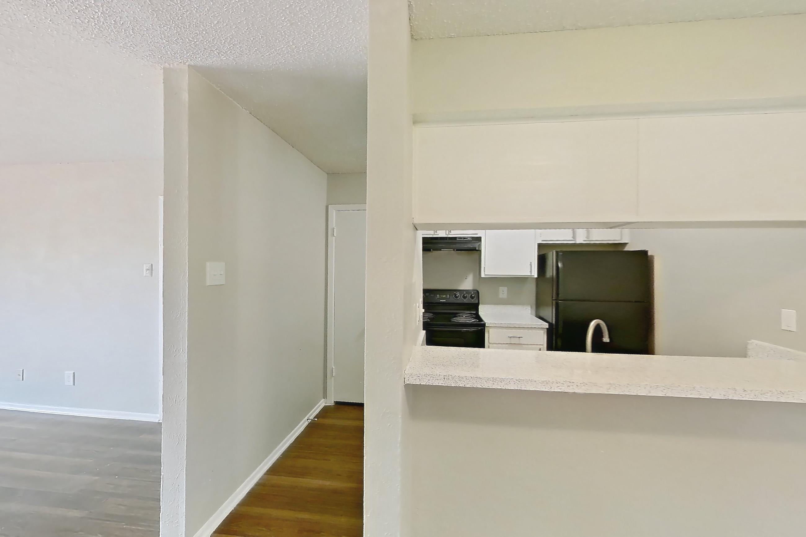 Dining room with black appliances, dark wood-finish flooring, electric range, light countertops, light stone countertops, oven/range, and refrigerator, Apartment 1002 at Westgate
