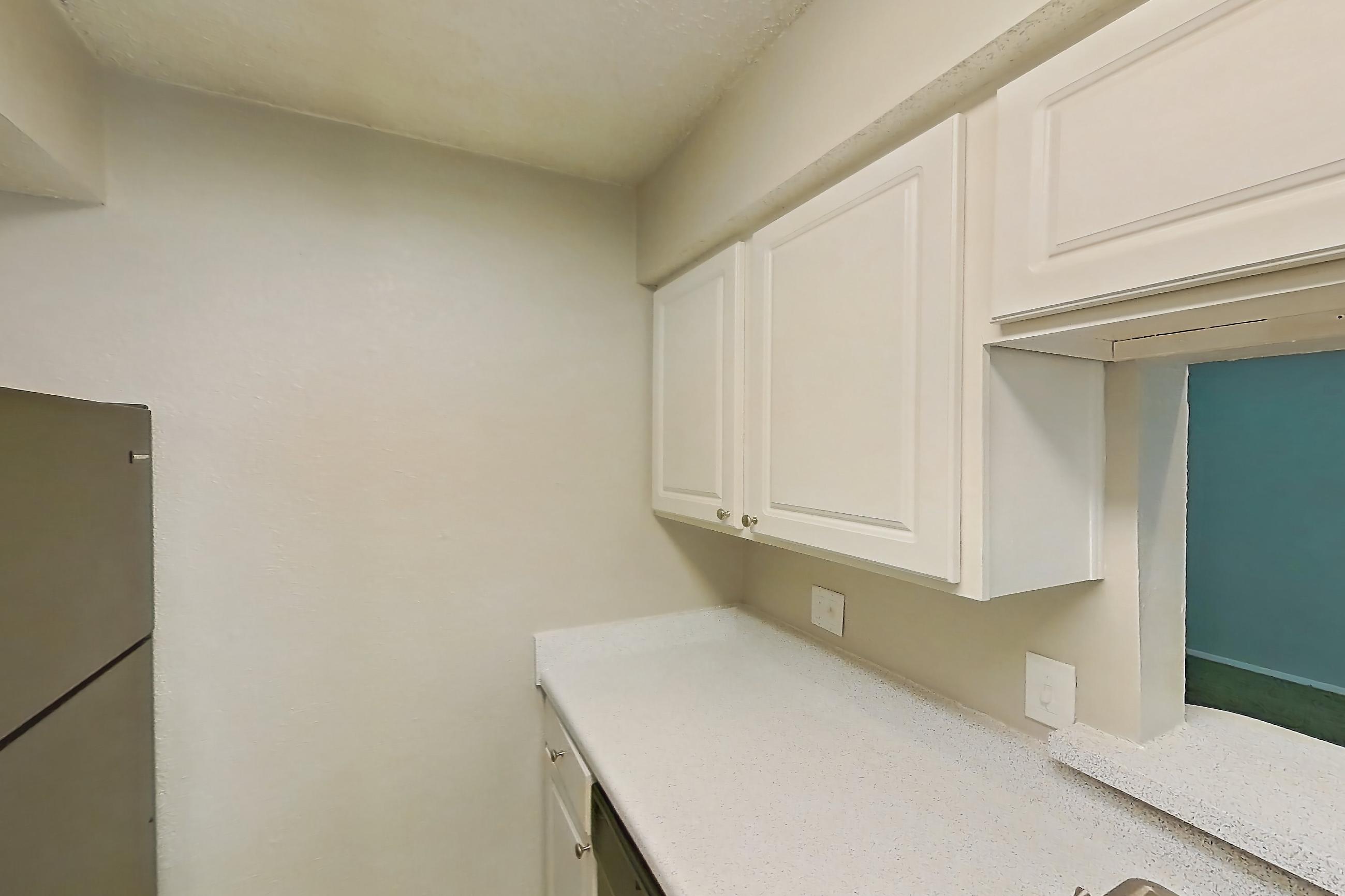 Kitchen with black appliances, dishwasher, electric range, light countertops, light stone countertops, light wood-finish flooring, oven/range, and refrigerator, Apartment 0807 at Prestonwood Apartment Homes
