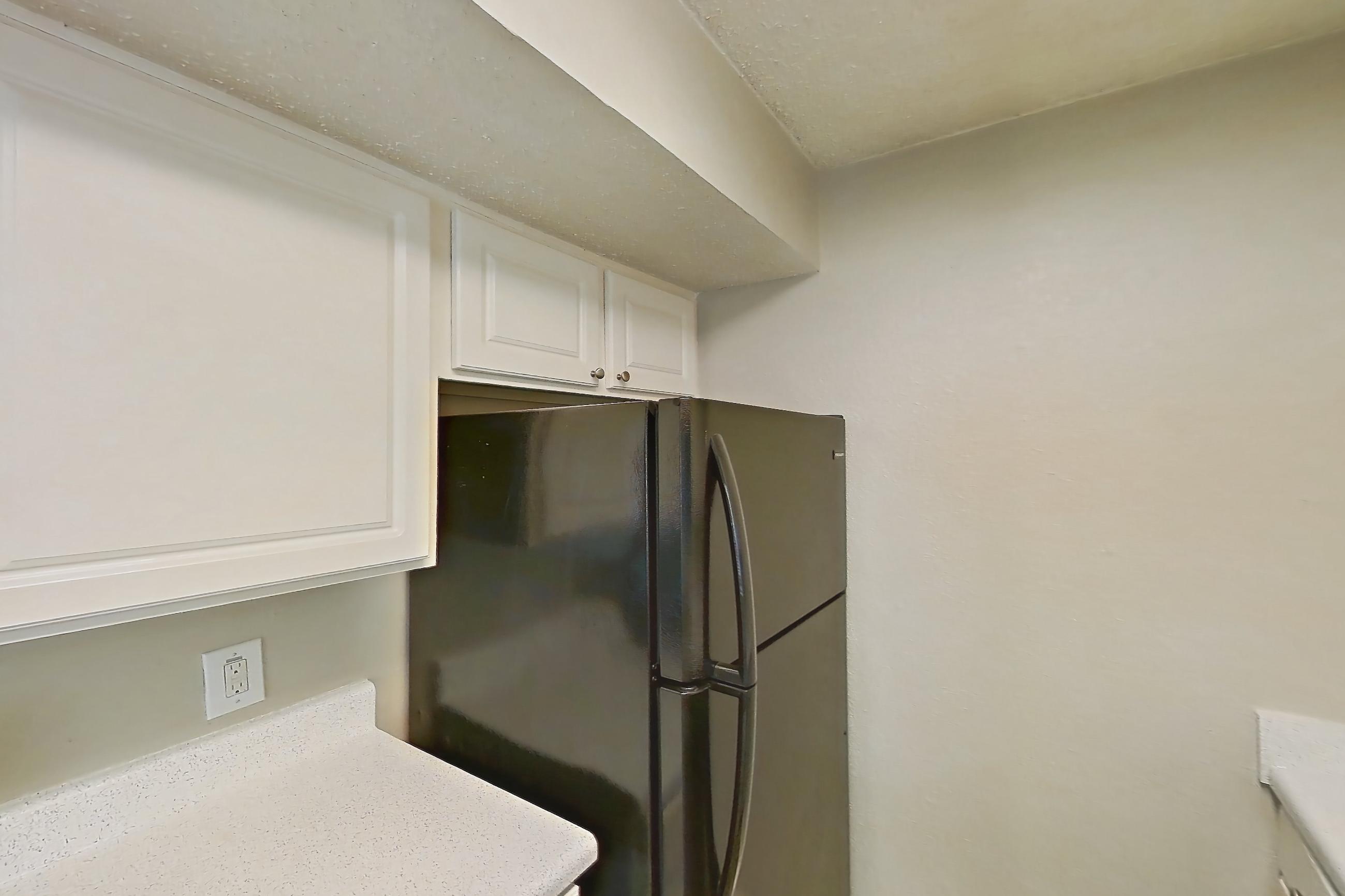 Kitchen with black appliances, dishwasher, electric range, light countertops, light stone countertops, light wood-finish flooring, oven/range, and refrigerator, Apartment 0807 at Prestonwood Apartment Homes