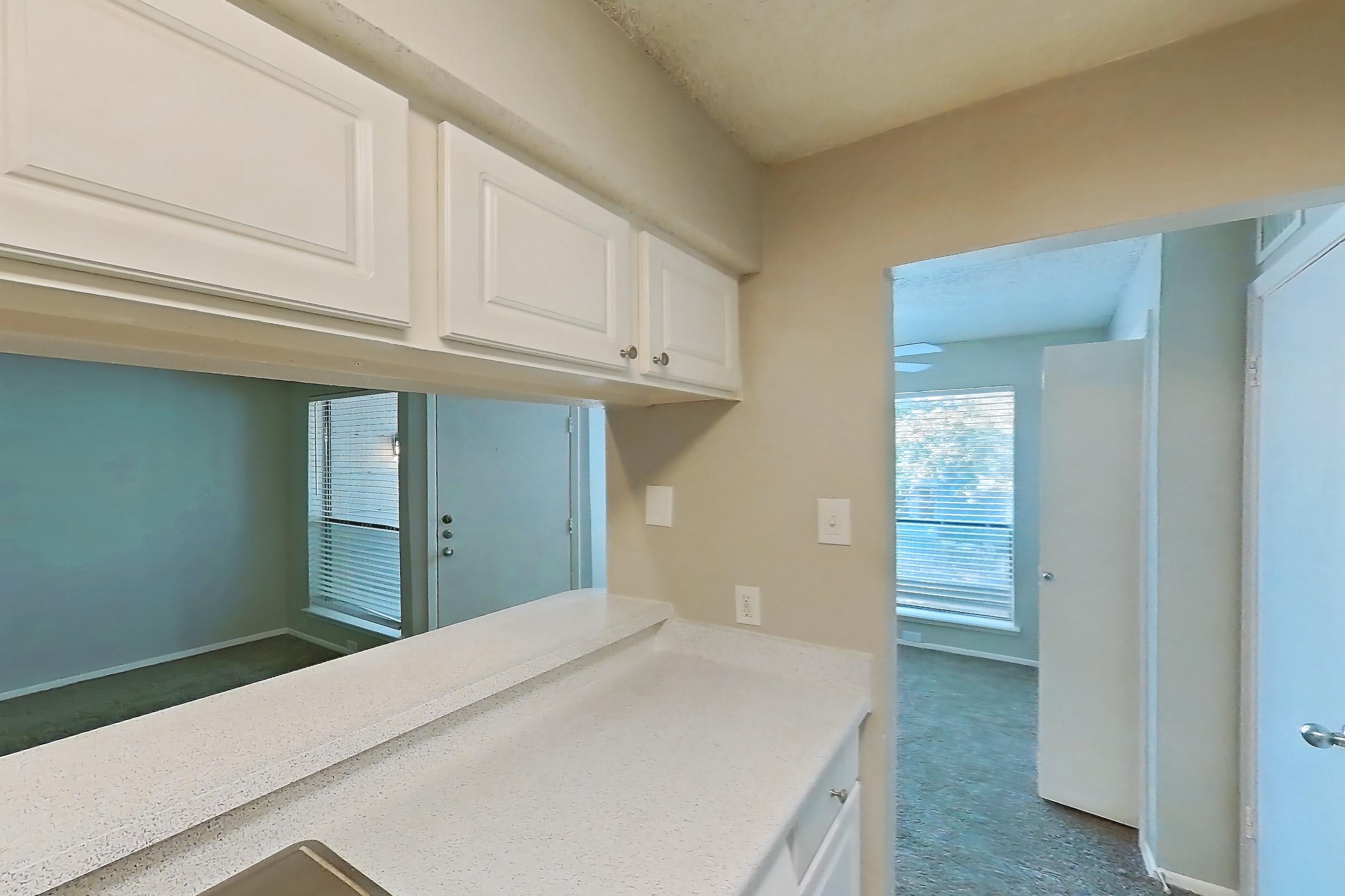 Kitchen with black appliances, dishwasher, electric range, light countertops, light stone countertops, light wood-finish flooring, oven/range, and refrigerator, Apartment 0807 at Prestonwood Apartment Homes