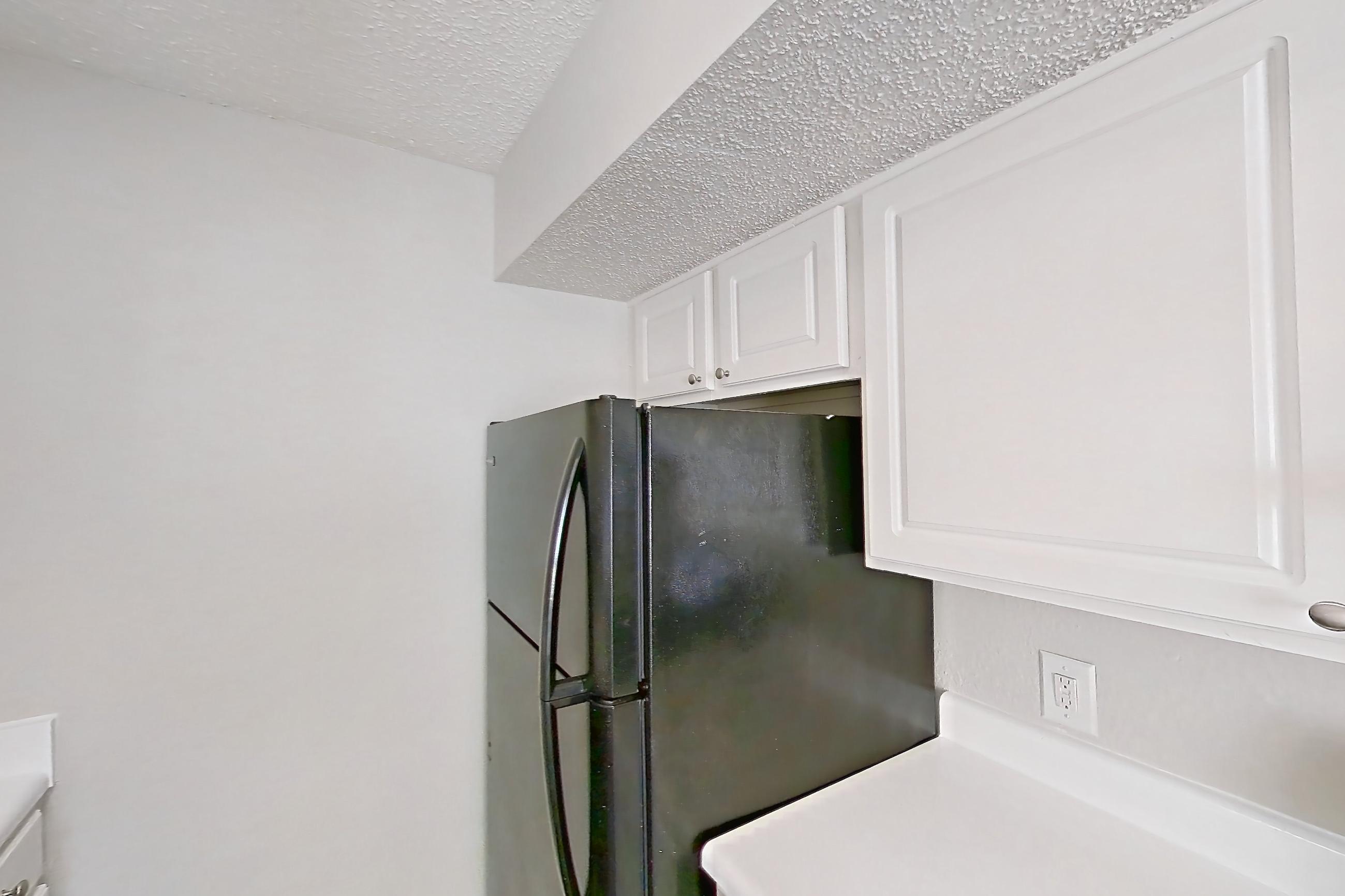Kitchen with black appliances, dark wood-finish flooring, dishwasher, electric range, light countertops, oven/range, and refrigerator, Apartment 1506 at Prestonwood Apartment Homes