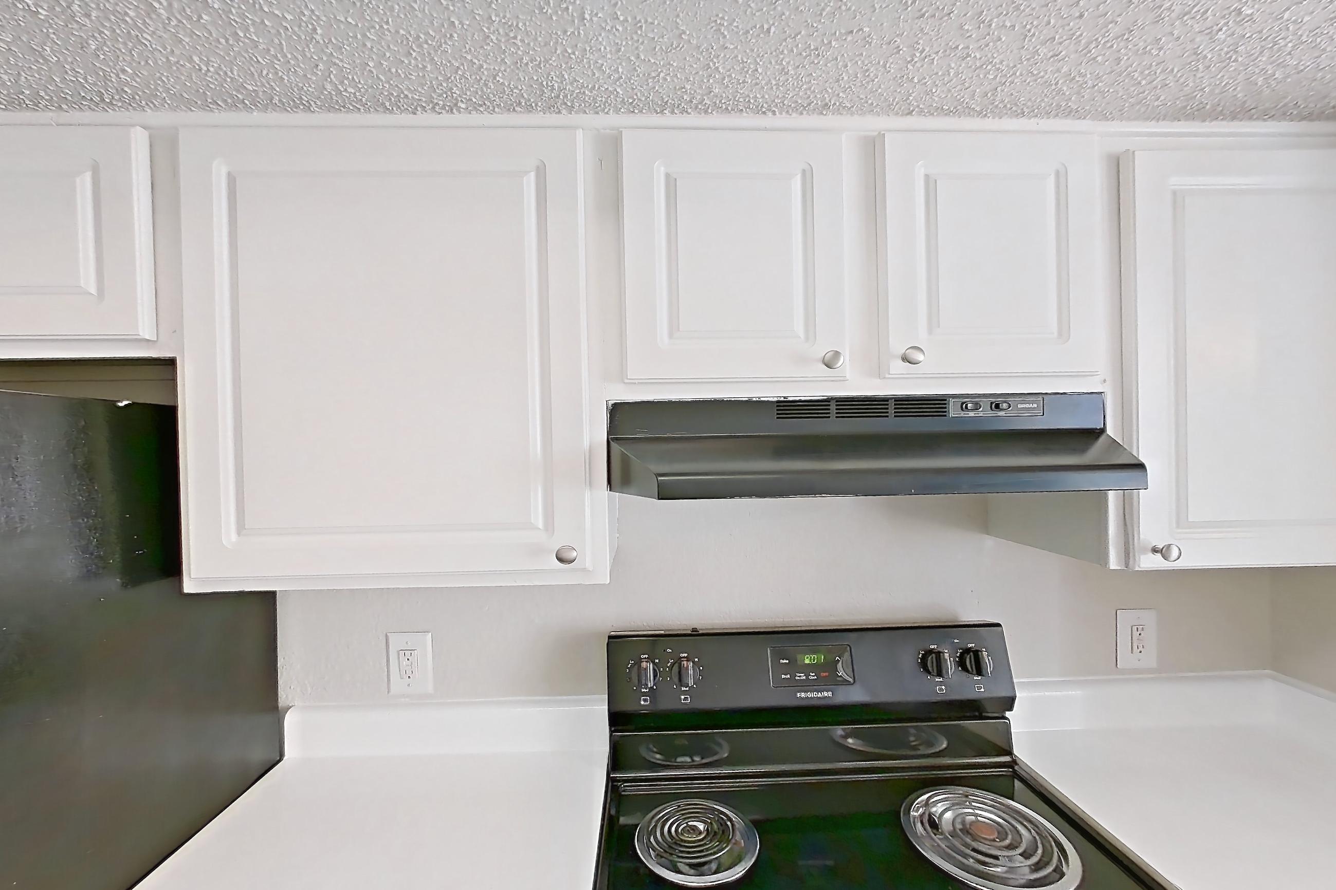 Kitchen with black appliances, dark wood-finish flooring, dishwasher, electric range, light countertops, oven/range, and refrigerator, Apartment 1506 at Prestonwood Apartment Homes