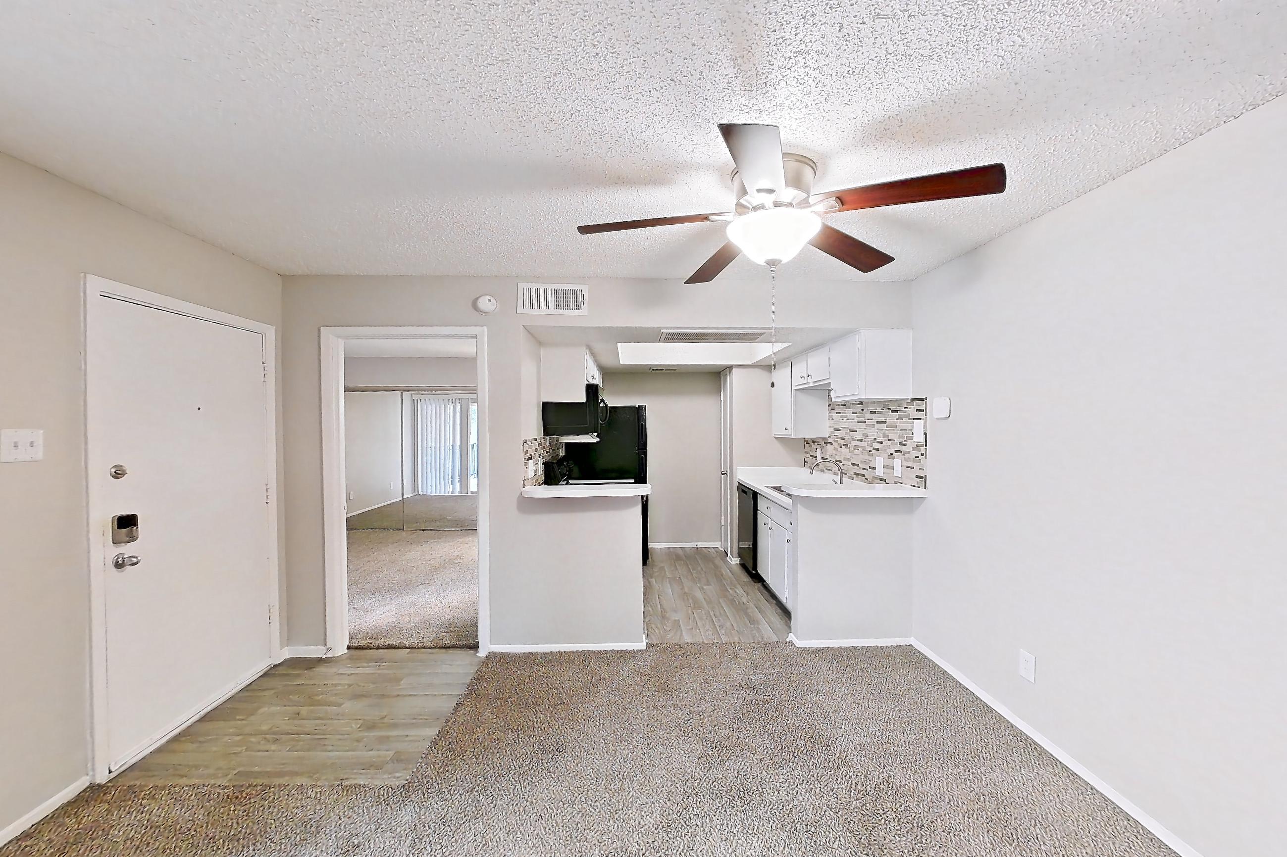 Living room with dishwasher, light carpet, and stainless steel appliances, Apartment 2013 at Enclave at Prestonwood