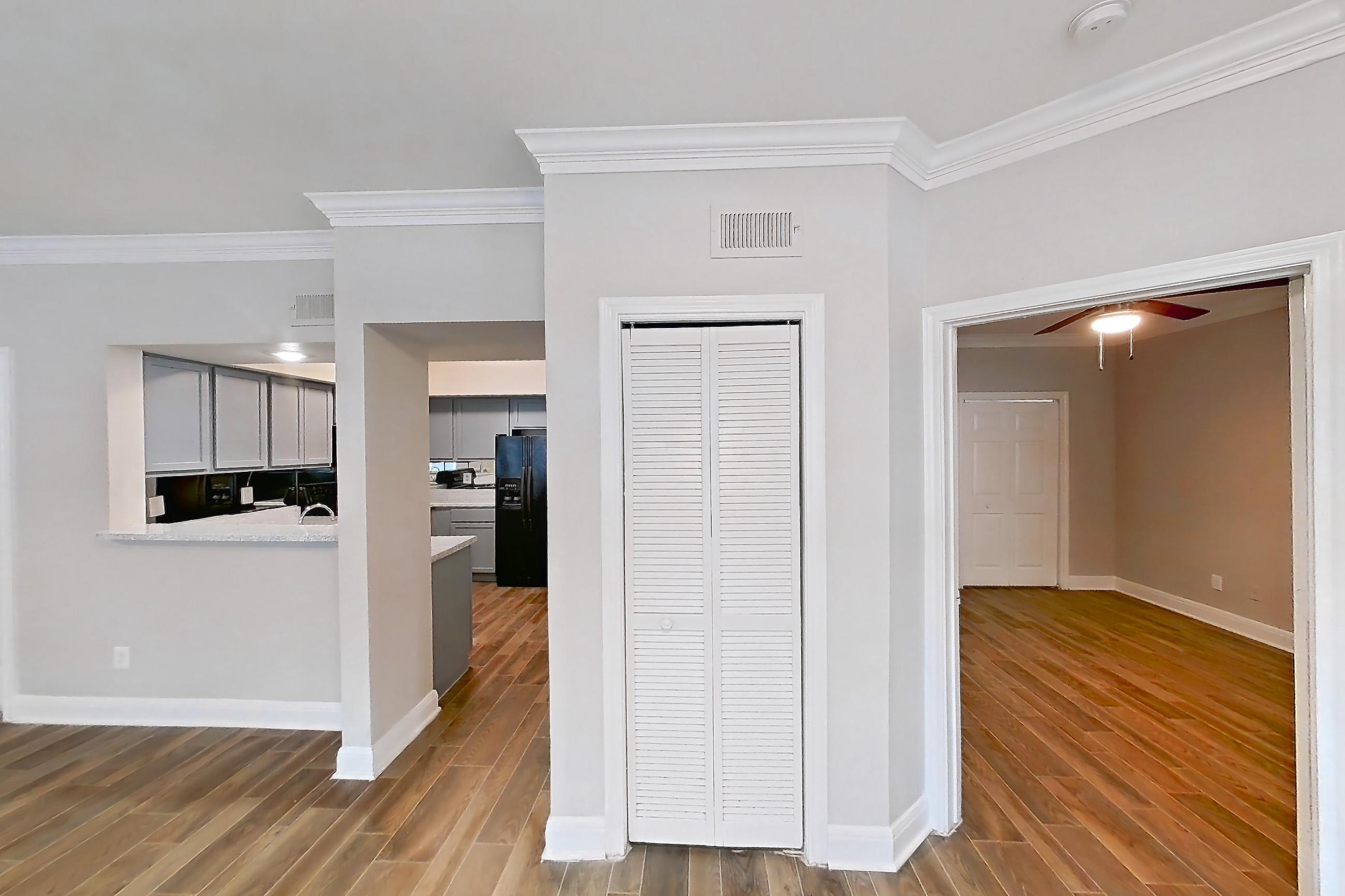Living space with black appliances, dark wood-finish flooring, refrigerator, water & ice dispenser, and wood-look tile flooring, Apartment 0301 at Champions Park