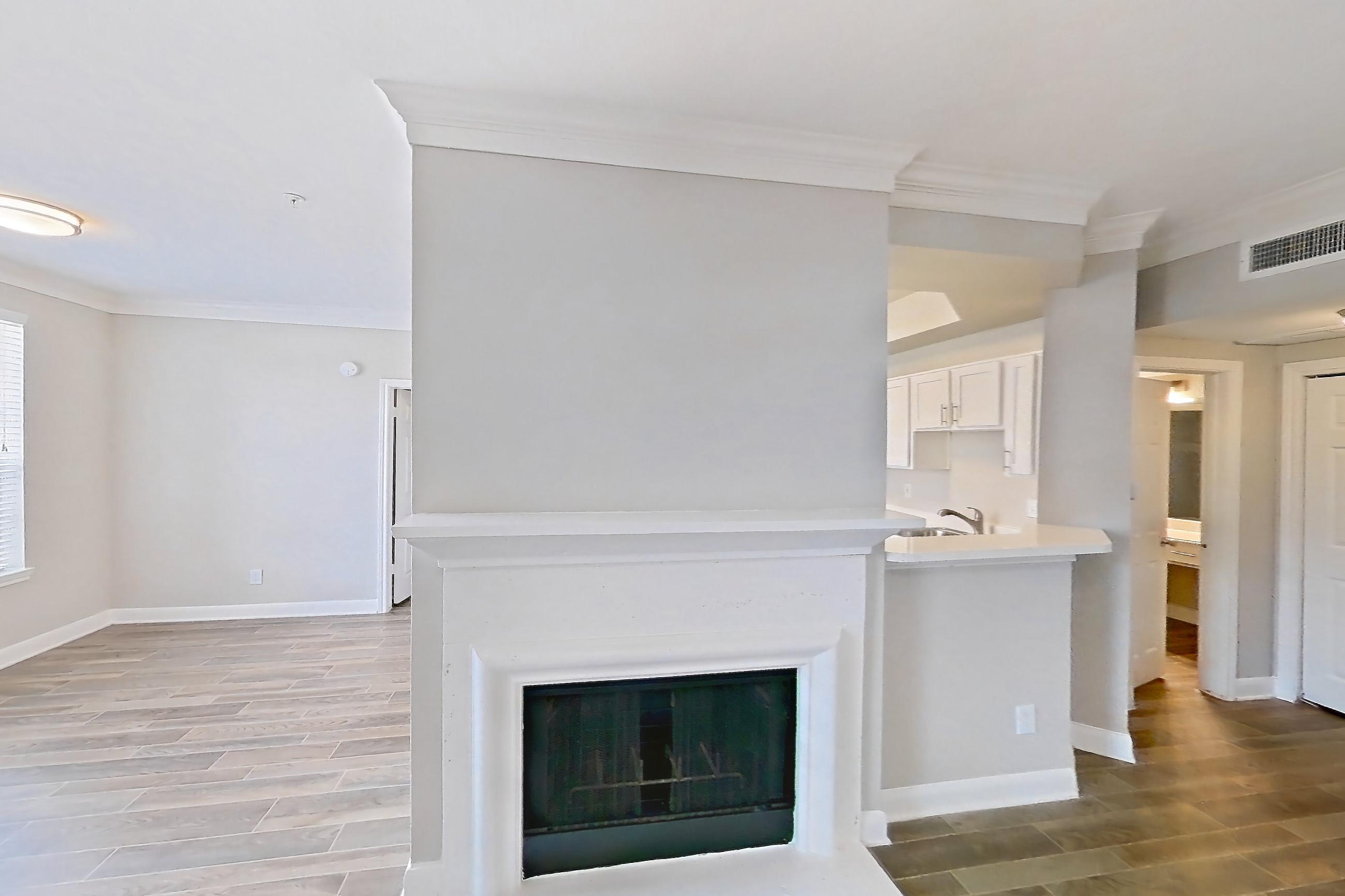 Living room with fireplace, light wood-finish flooring, and wood-look tile flooring, Apartment 609 at Champions Centre