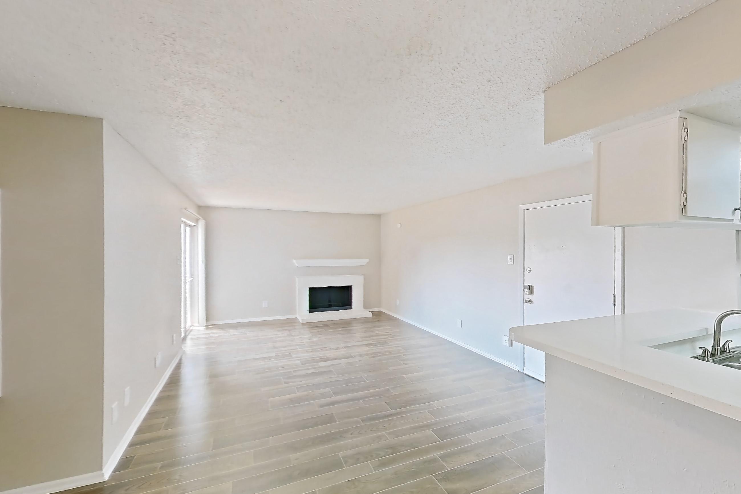 Dining room with fireplace, light countertops, light wood-finish flooring, refrigerator, white appliances, and wood-look tile flooring, Apartment 1156 at Enclave at Prestonwood