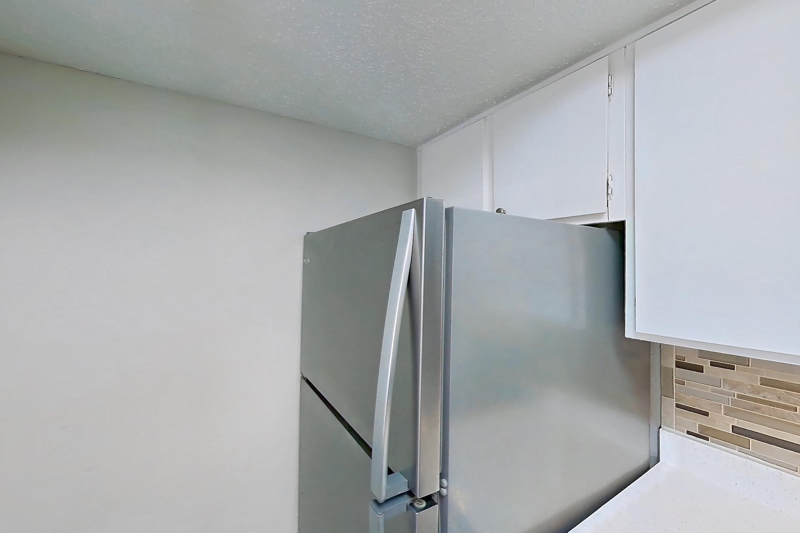 Kitchen with black appliances, dishwasher, electric range, fireplace, light countertops, light wood-finish flooring, oven/range, refrigerator, stainless steel appliances, and wood-look tile flooring, Apartment 1156 at Enclave at Prestonwood