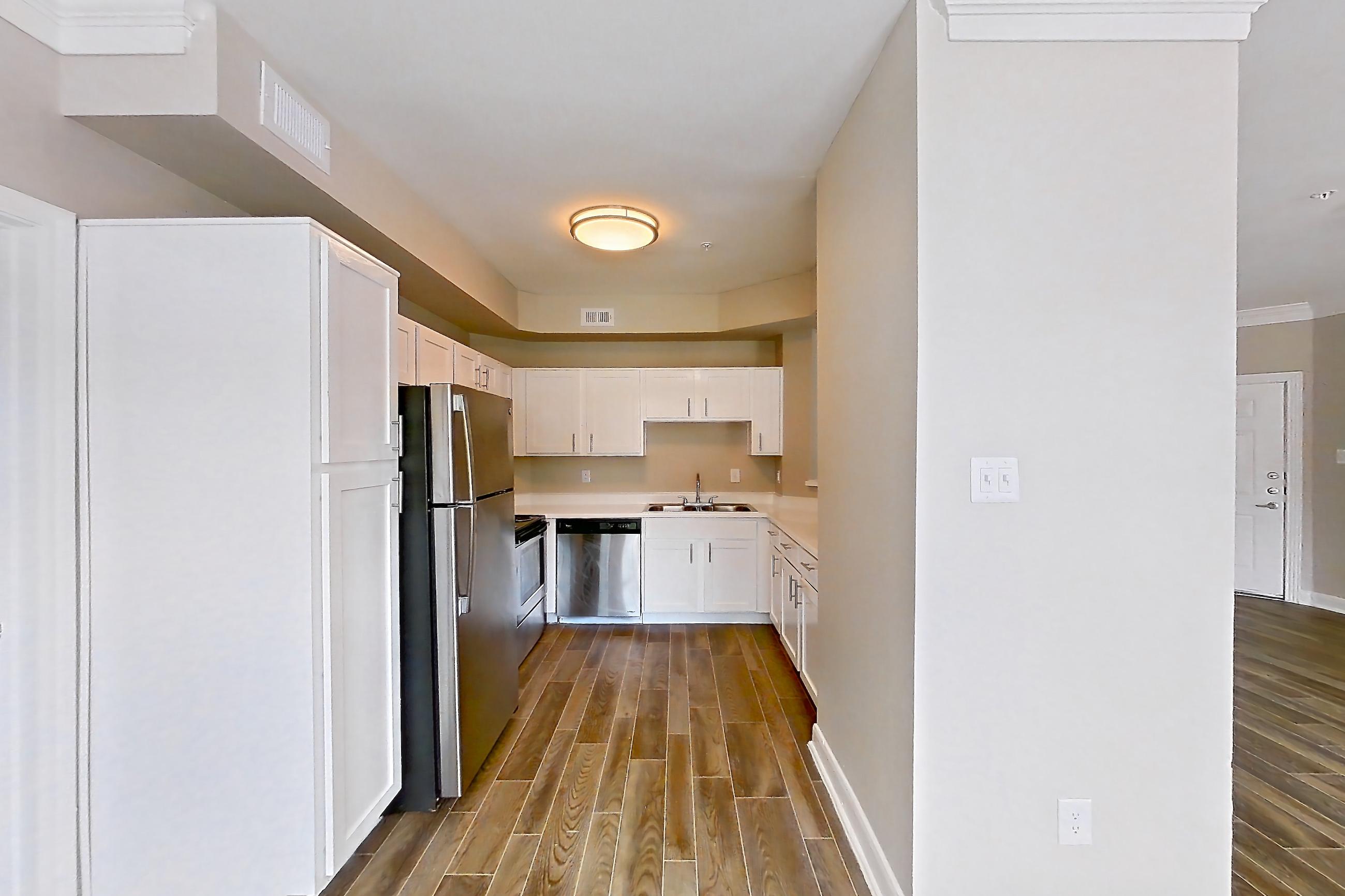 Dining room with dishwasher, electric range, light countertops, light wood-finish flooring, oven/range, refrigerator, stainless steel appliances, and wood-look tile flooring, Apartment 805 at Champions Centre