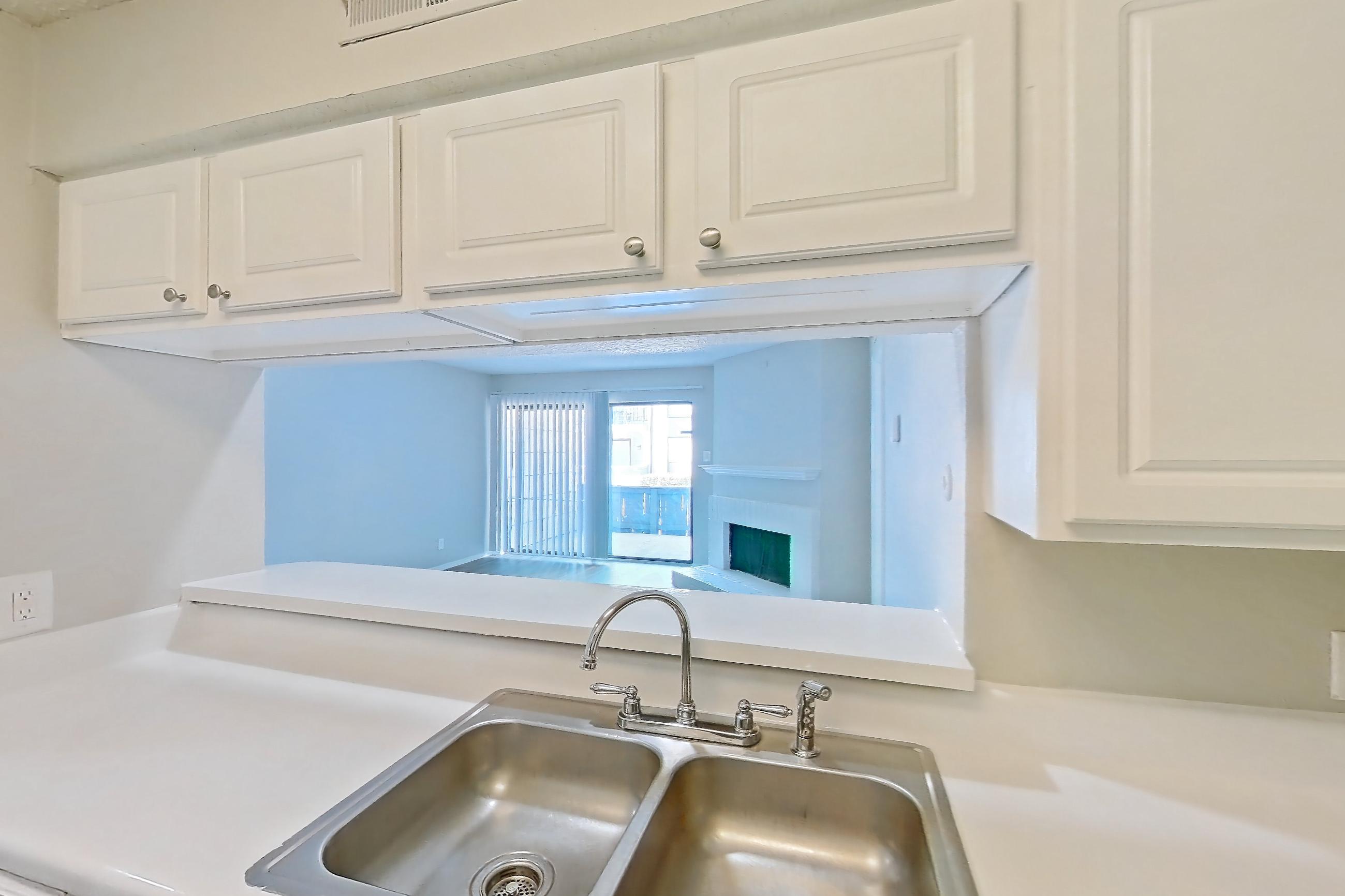 Kitchen with black appliances, electric range, fireplace, light countertops, light wood-finish flooring, oven/range, range hood, and wood-look tile flooring, Apartment 1006 at Prestonwood Apartment Homes