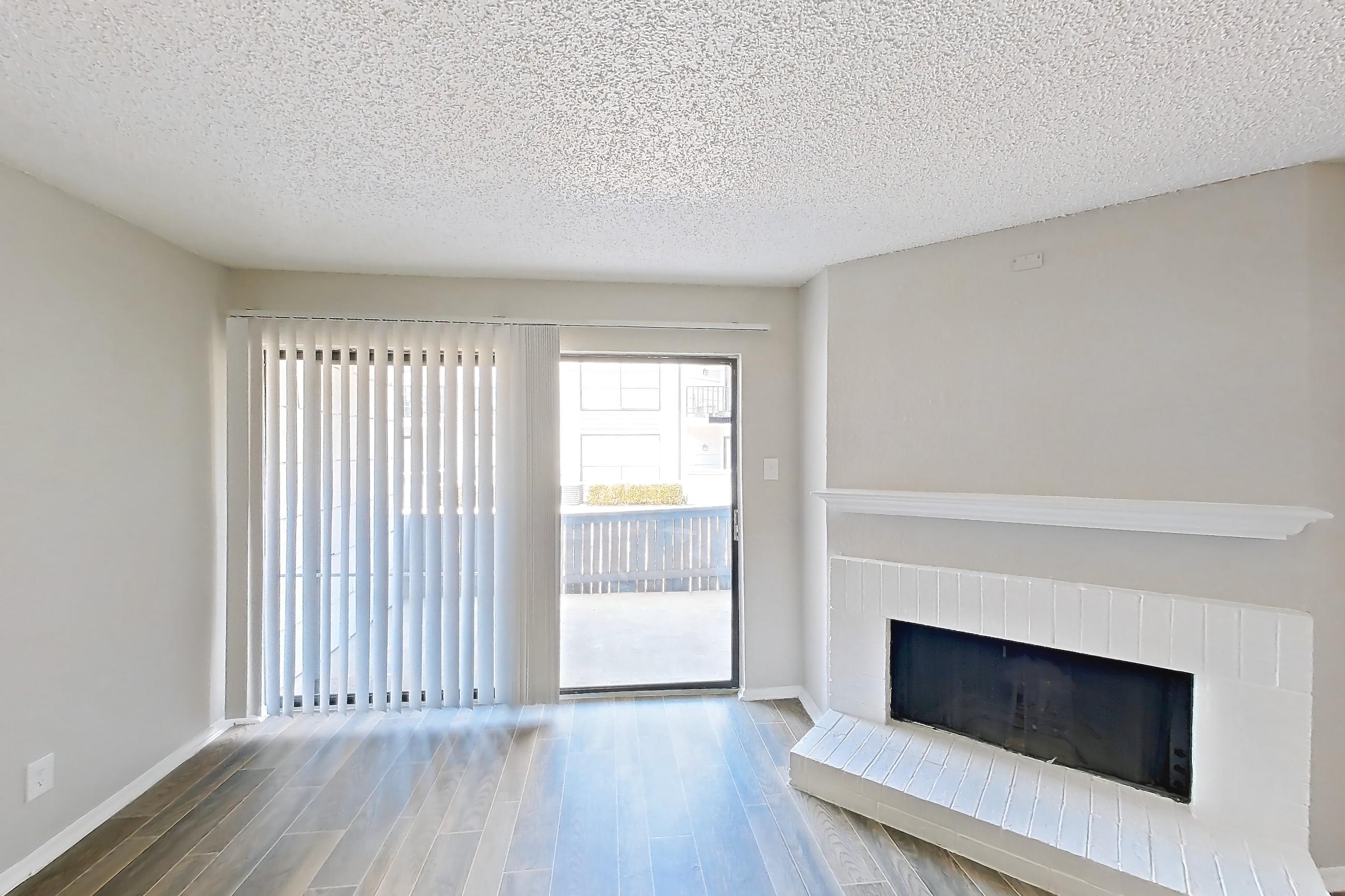 Living room with brick fireplace, fireplace, light wood-finish flooring, and wood-look tile flooring, Apartment 1006 at Prestonwood Apartment Homes