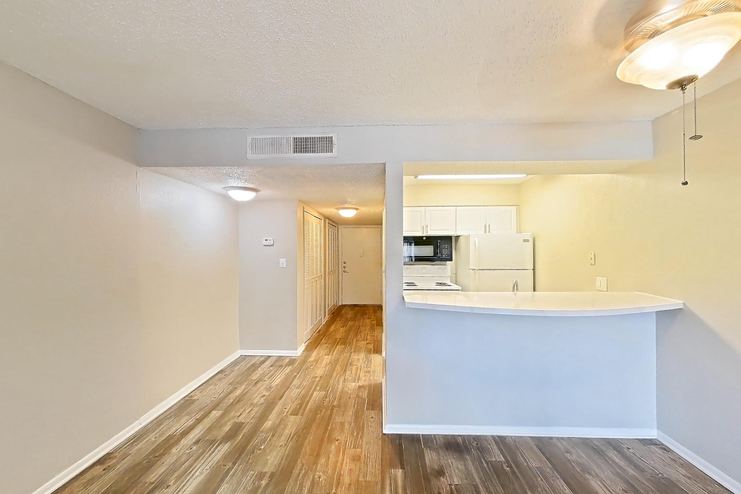 Living room with dark wood-finish flooring, electric range, oven/range, refrigerator, and white appliances, Apartment C-08 at Sunset Place