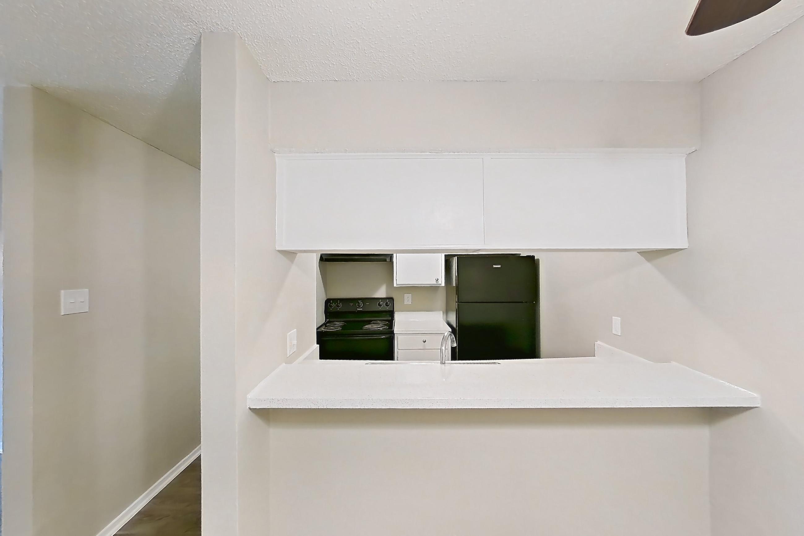 Dining room with black appliances, dark wood-finish flooring, electric range, light countertops, light wood-finish flooring, oven/range, and refrigerator, Apartment 809 at Westgate