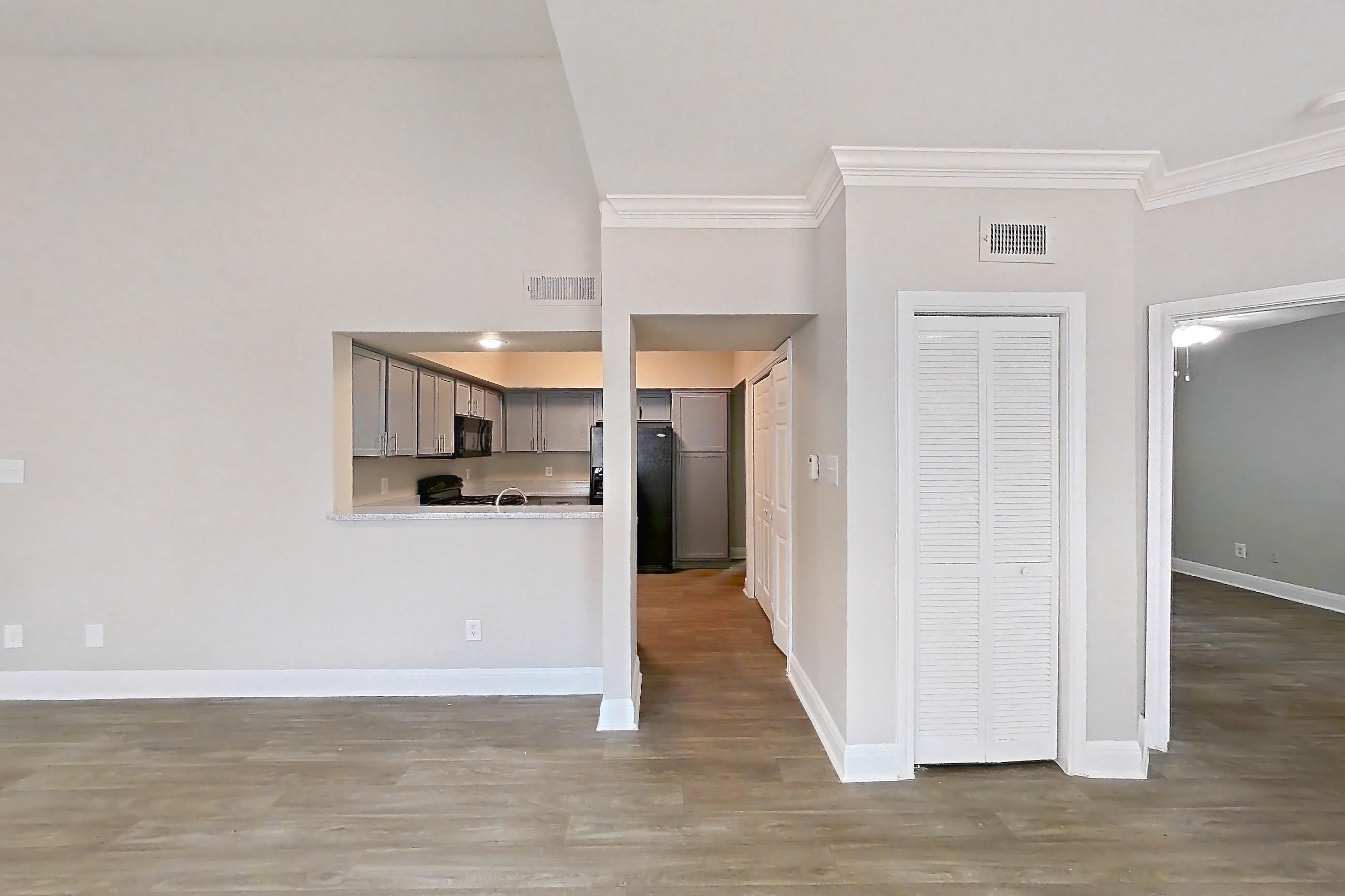 Living room with dark wood-finish flooring, light wood-finish flooring, and refrigerator, Unit 0420 at Champions Park