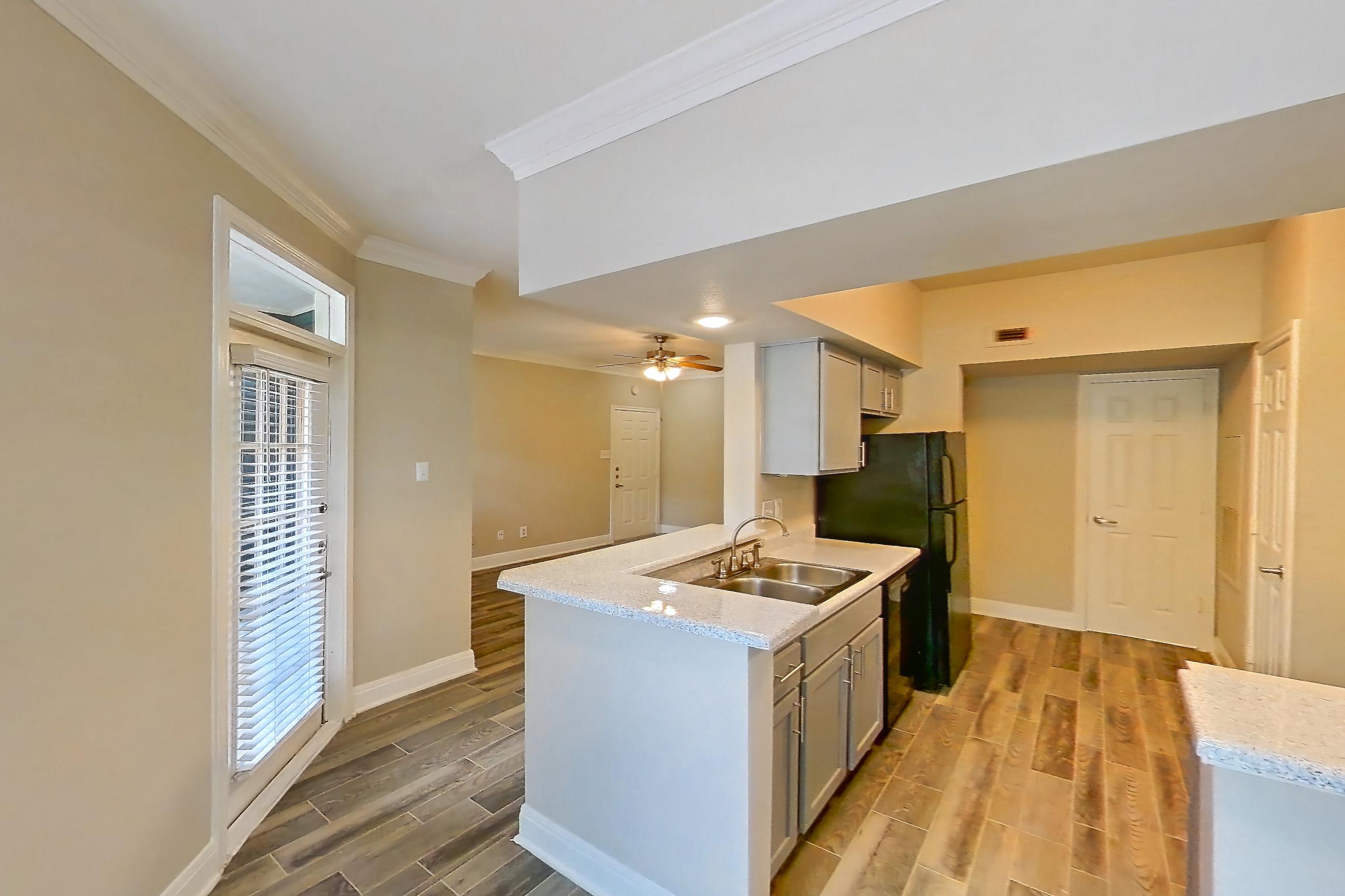 Dining room with black appliances, dark wood-finish flooring, electric range, light stone countertops, light wood-finish flooring, oven/range, refrigerator, and wood-look tile flooring, Apartment 0610 at Champions Park