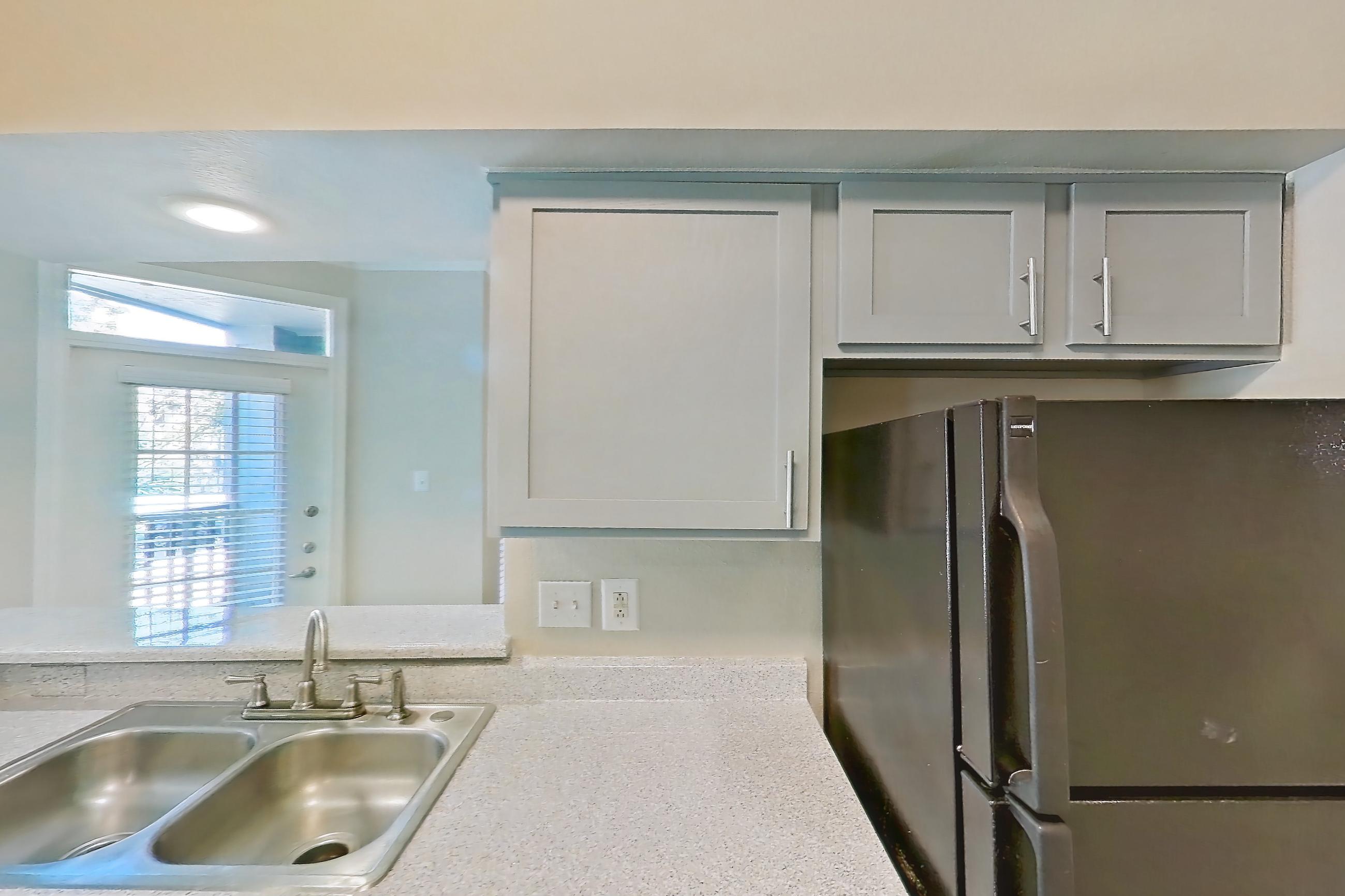 Kitchen with black appliances, dishwasher, electric range, light countertops, light stone countertops, light wood-finish flooring, microwave, oven/range, and wood-look tile flooring, Apartment 0610 at Champions Park