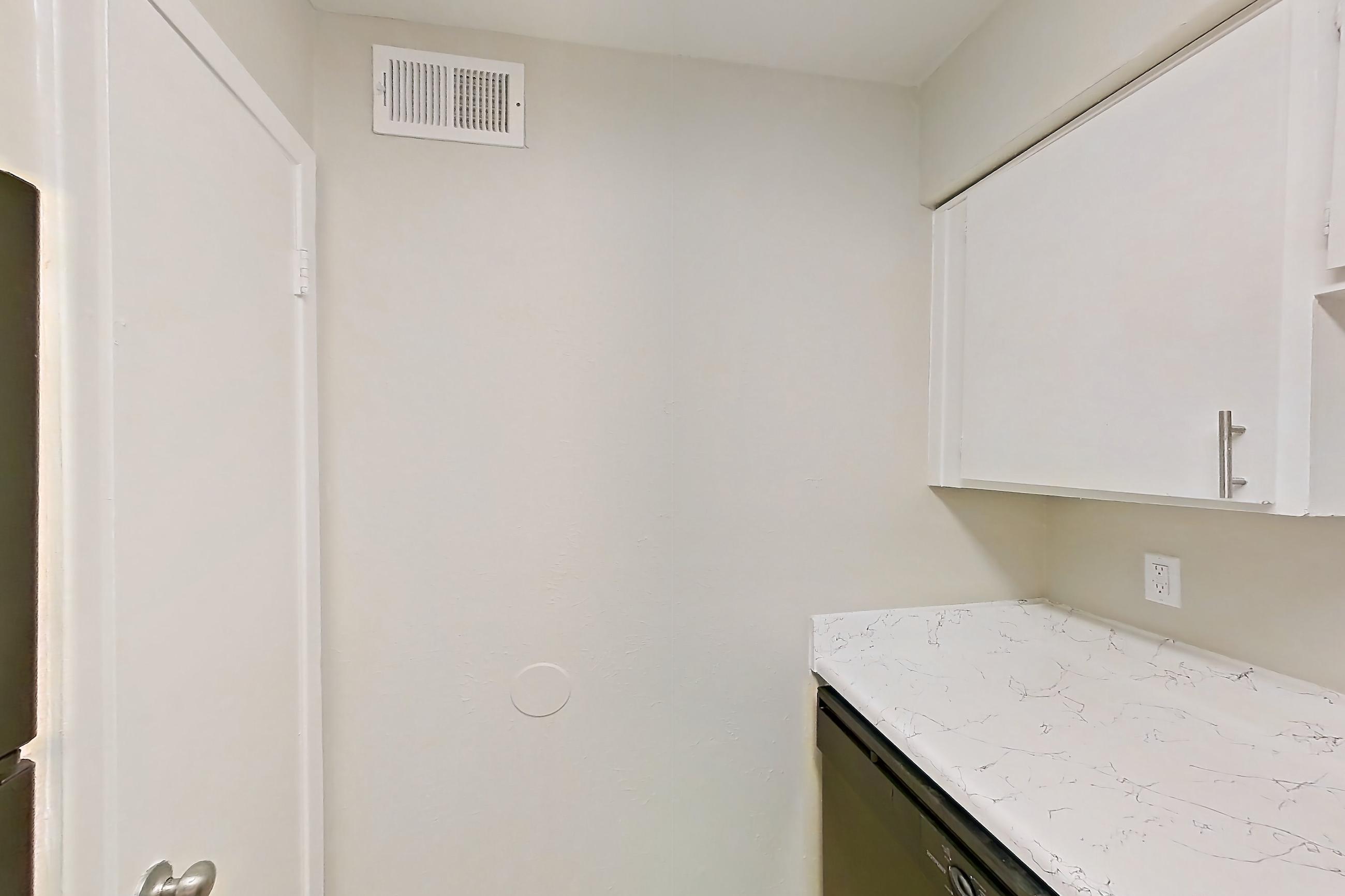 Kitchen with black appliances, dishwasher, electric range, light countertops, light stone countertops, light wood-finish flooring, oven/range, and range hood, Apartment 1322 at Westgate