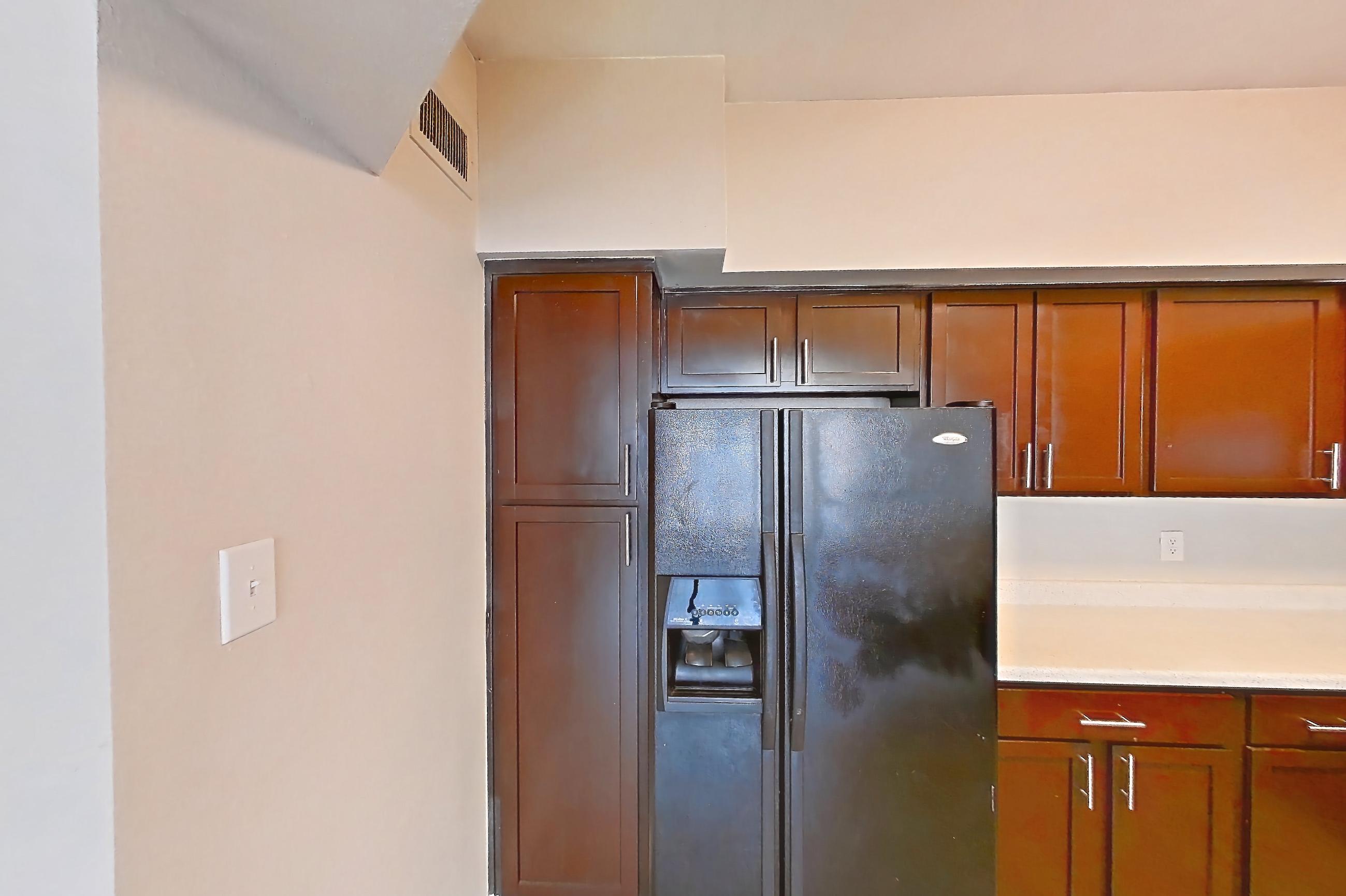 Kitchen space with black appliances, electric range, light countertops, light wood-finish flooring, oven/range, refrigerator, and water & ice dispenser, Apartment 0812 at Champions Park