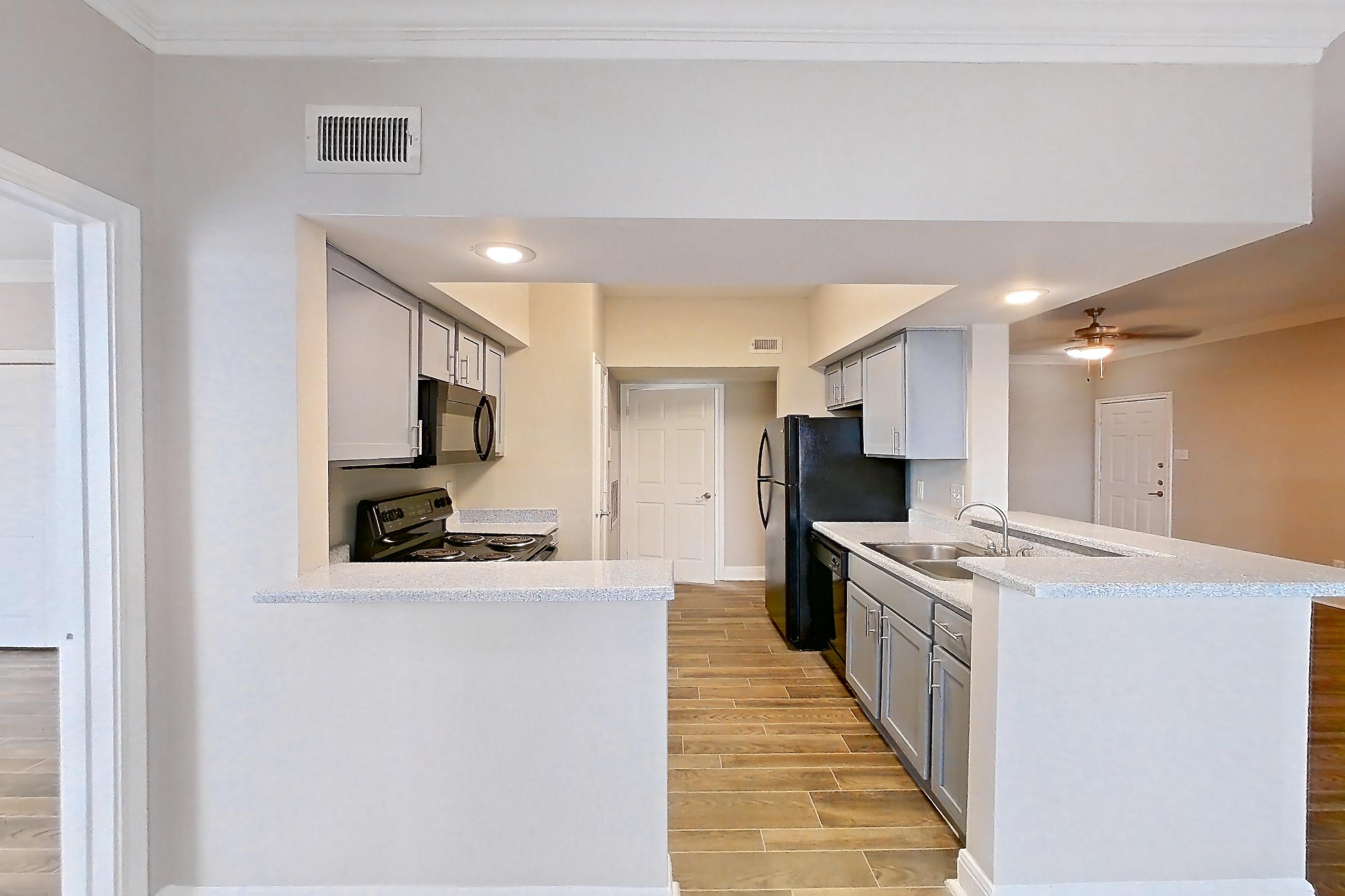 Dining room with black appliances, dishwasher, electric range, light countertops, light wood-finish flooring, microwave, oven/range, refrigerator, and wood-look tile flooring, Unit 0917 at Champions Park
