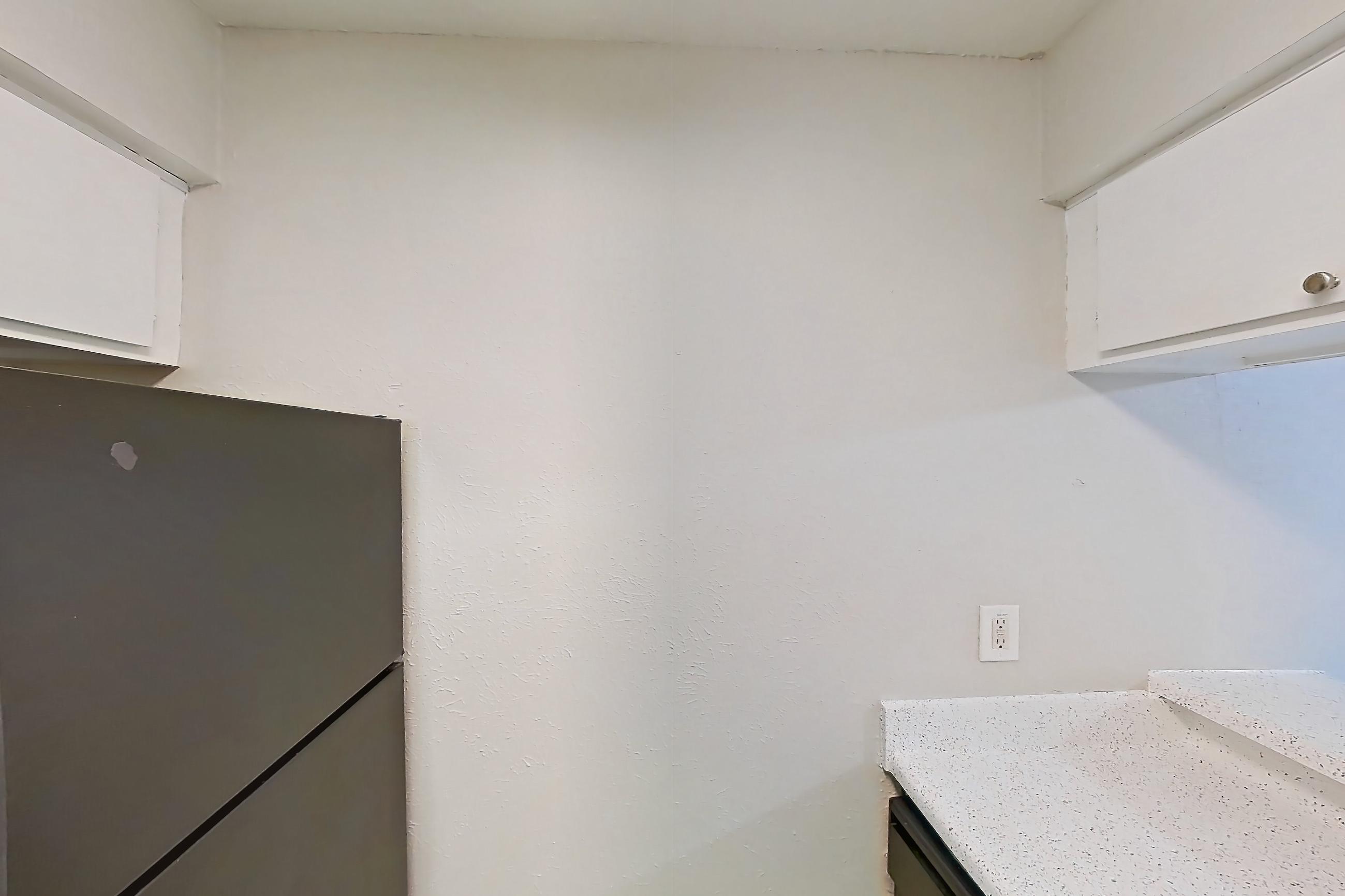 Kitchen with black appliances, dishwasher, electric range, light countertops, light stone countertops, light wood-finish flooring, oven/range, and refrigerator, Apartment 2121 at Westgate