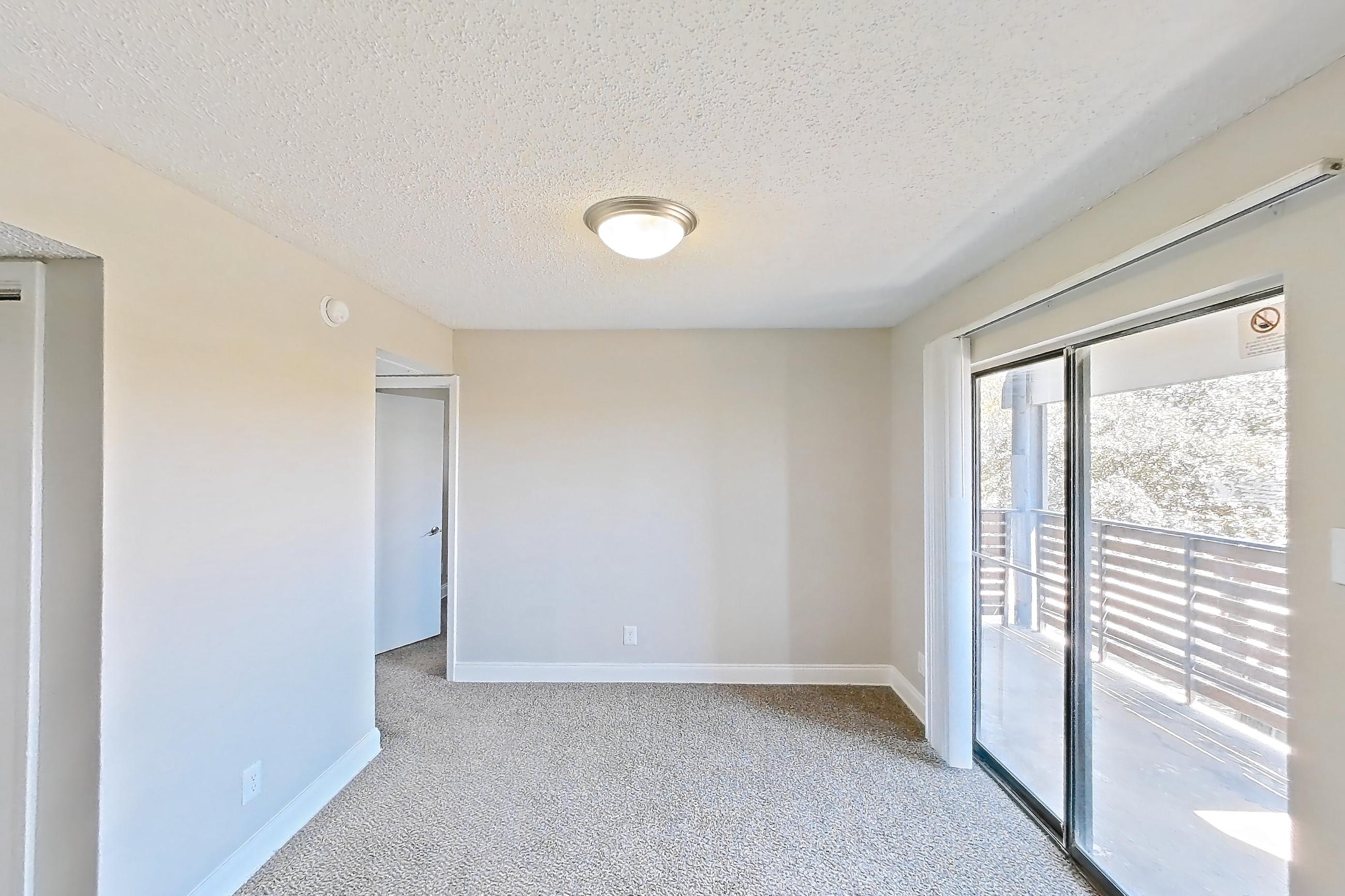 Living room with black appliances, dark carpet, electric range, fireplace, light countertops, oven/range, and wood-look tile flooring, Apartment 232 at Sedona Park