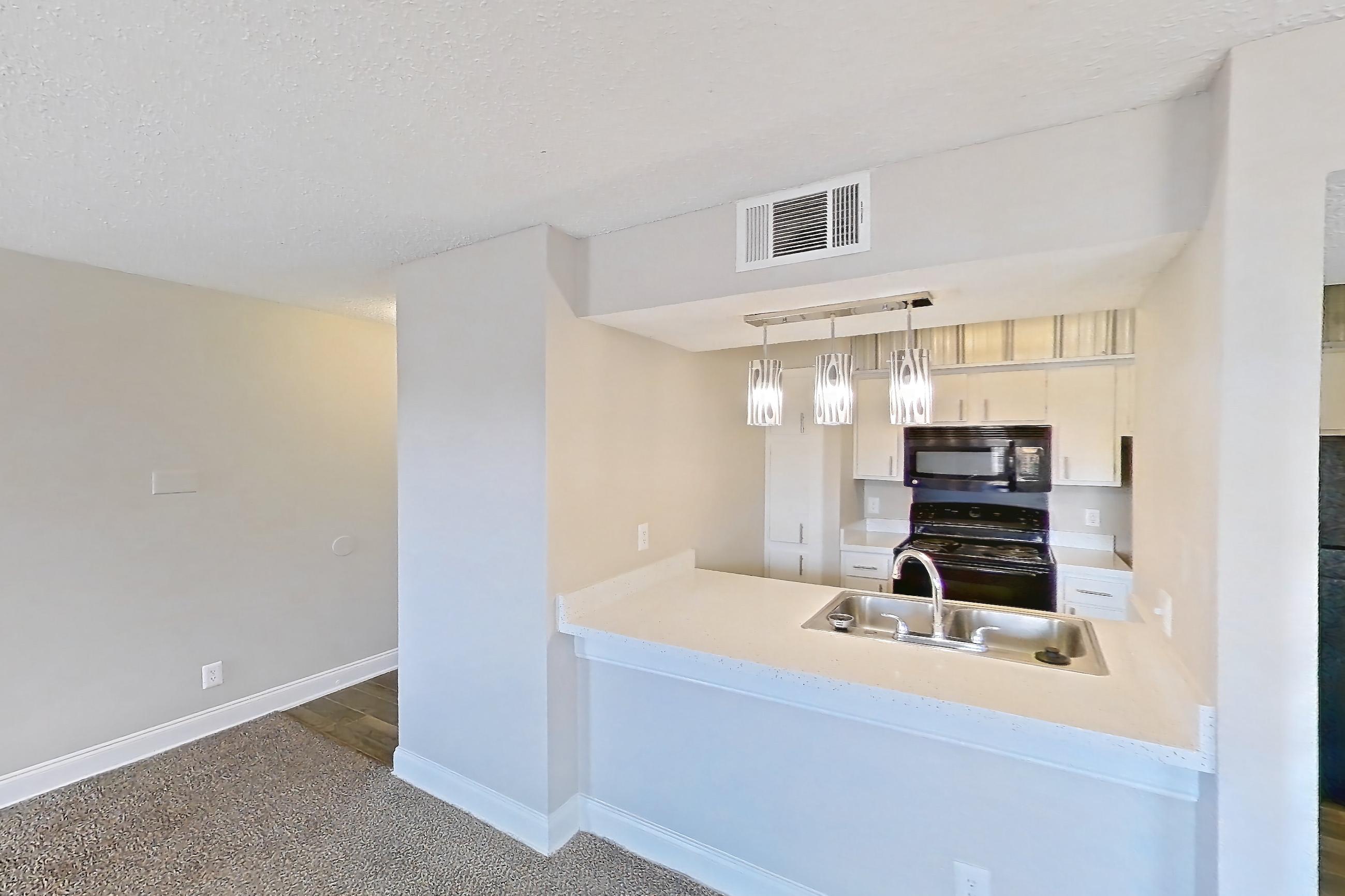 Living room with black appliances, dark carpet, electric range, fireplace, light countertops, oven/range, and wood-look tile flooring, Apartment 232 at Sedona Park