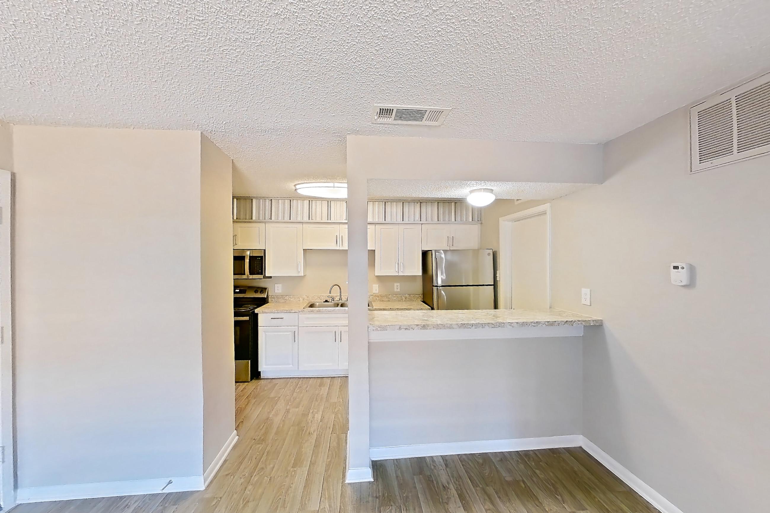 Living room with electric range, light wood-finish flooring, oven/range, refrigerator, and stainless steel appliances, Apartment 160 at Sedona Park