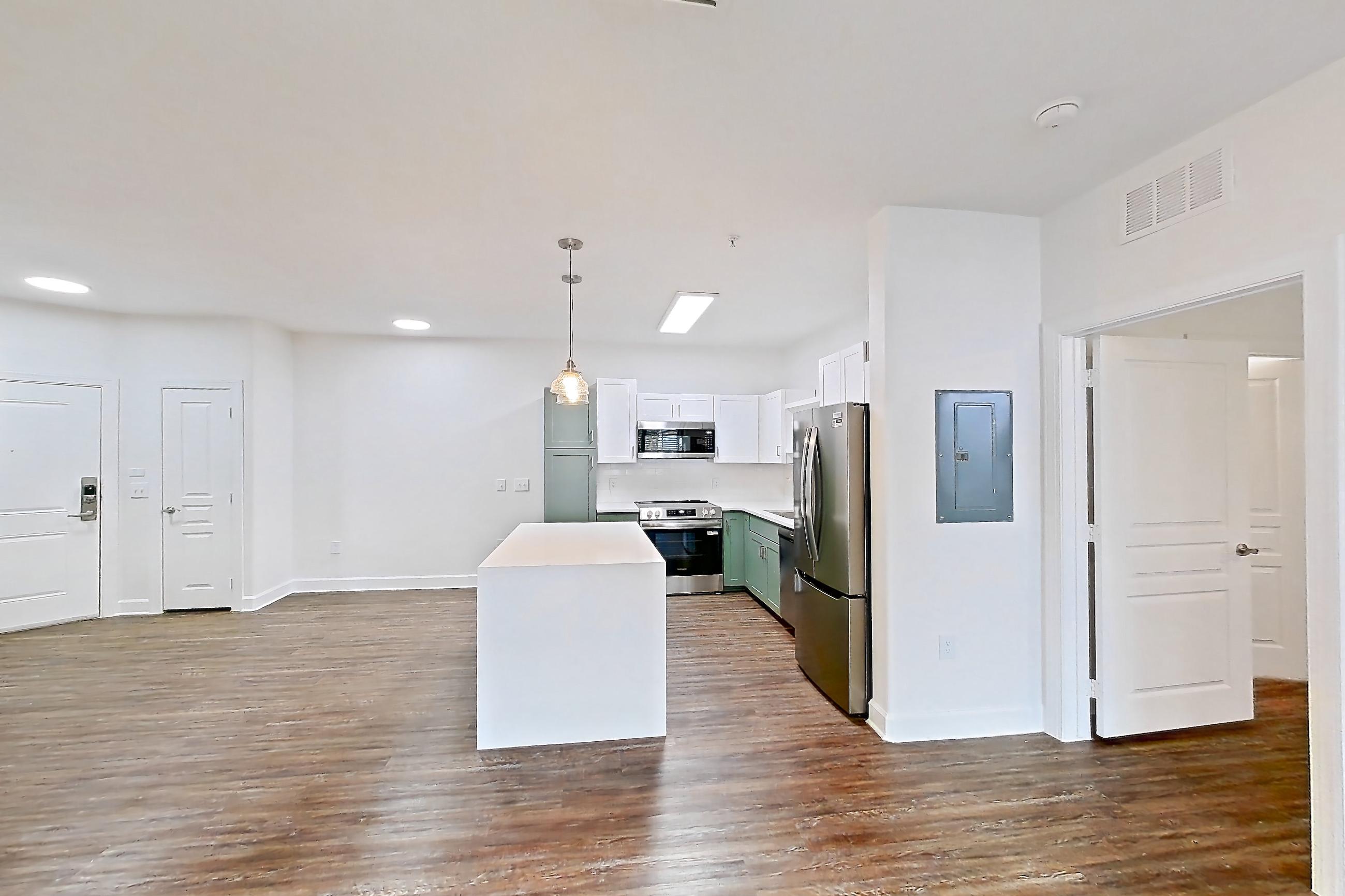 Living room with dark wood-finish flooring, electric range, light countertops, oven/range, refrigerator, and stainless steel appliances, Apartment 208 at Talcott at Windermere