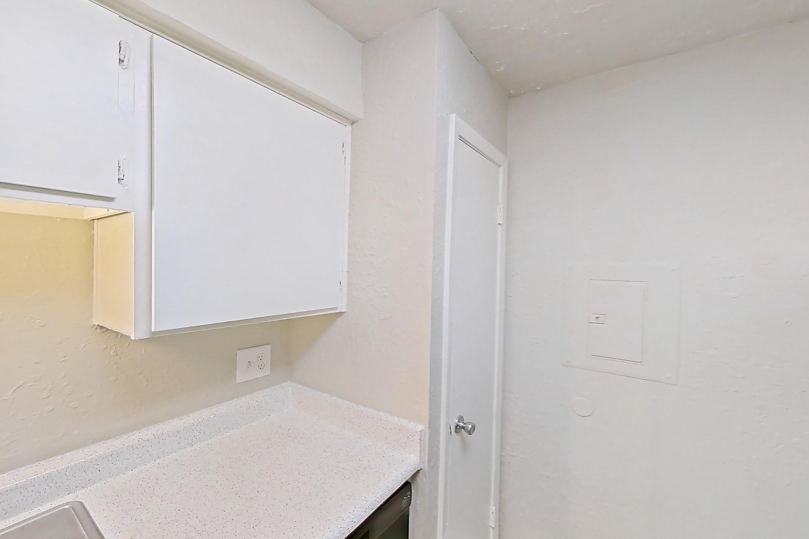 Kitchen with black appliances, electric range, light countertops, light stone countertops, light wood-finish flooring, oven/range, and refrigerator, Apartment 118B at The Carmel