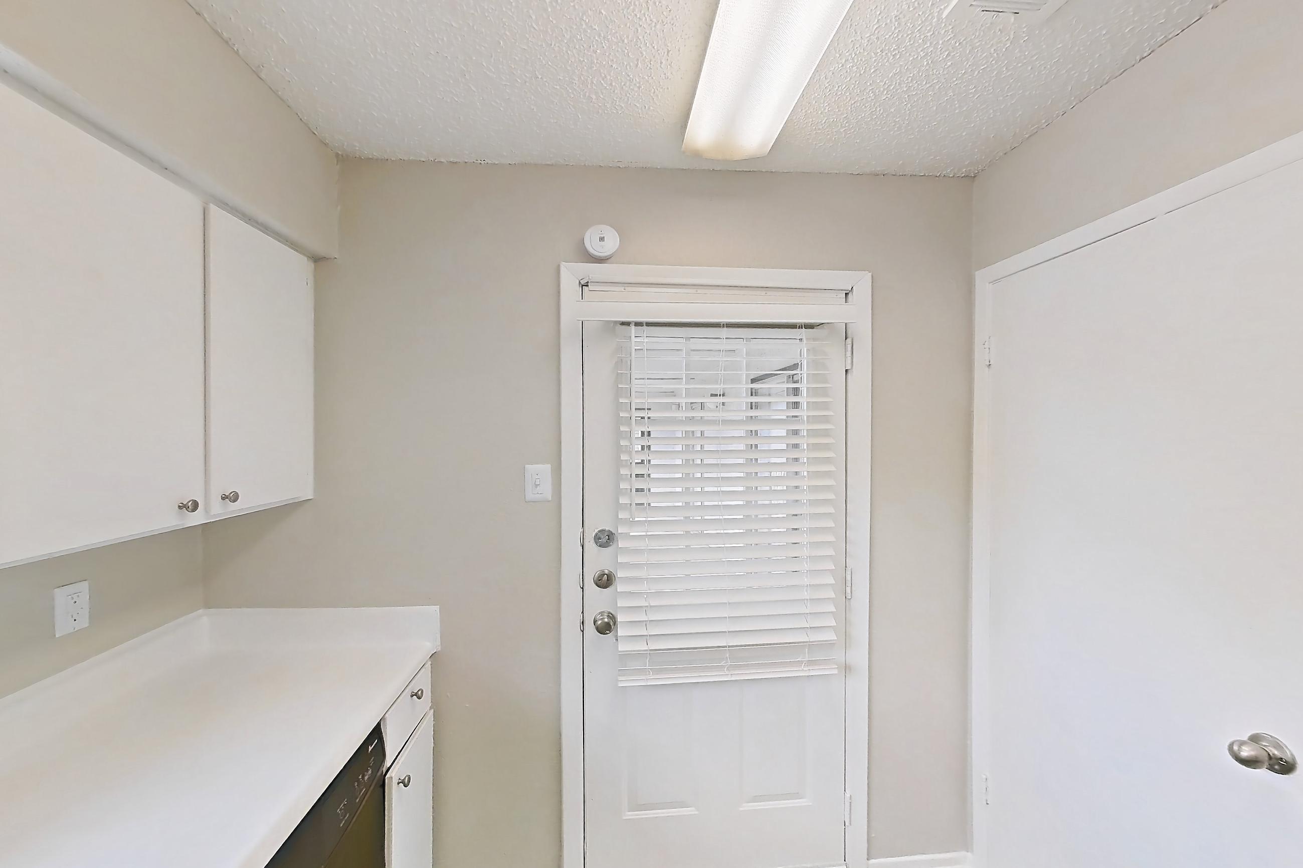 Kitchen with black appliances, dishwasher, light countertops, light wood-finish flooring, and refrigerator, Apartment 0306 at Bella Vista