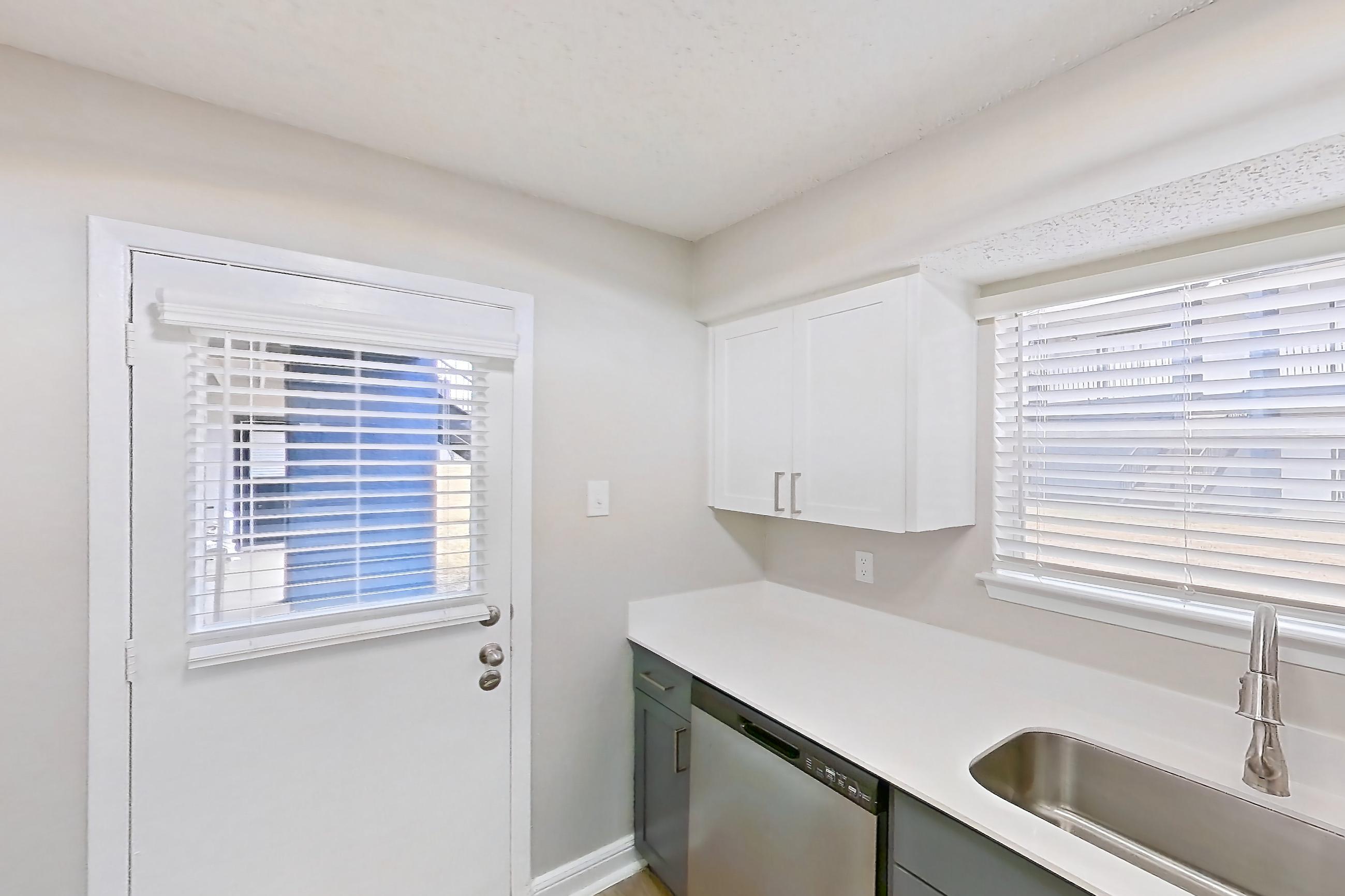 Kitchen with dishwasher, electric range, light countertops, light stone countertops, light wood-finish flooring, microwave, oven/range, refrigerator, and stainless steel appliances, Apartment 1003 at Bella Vista