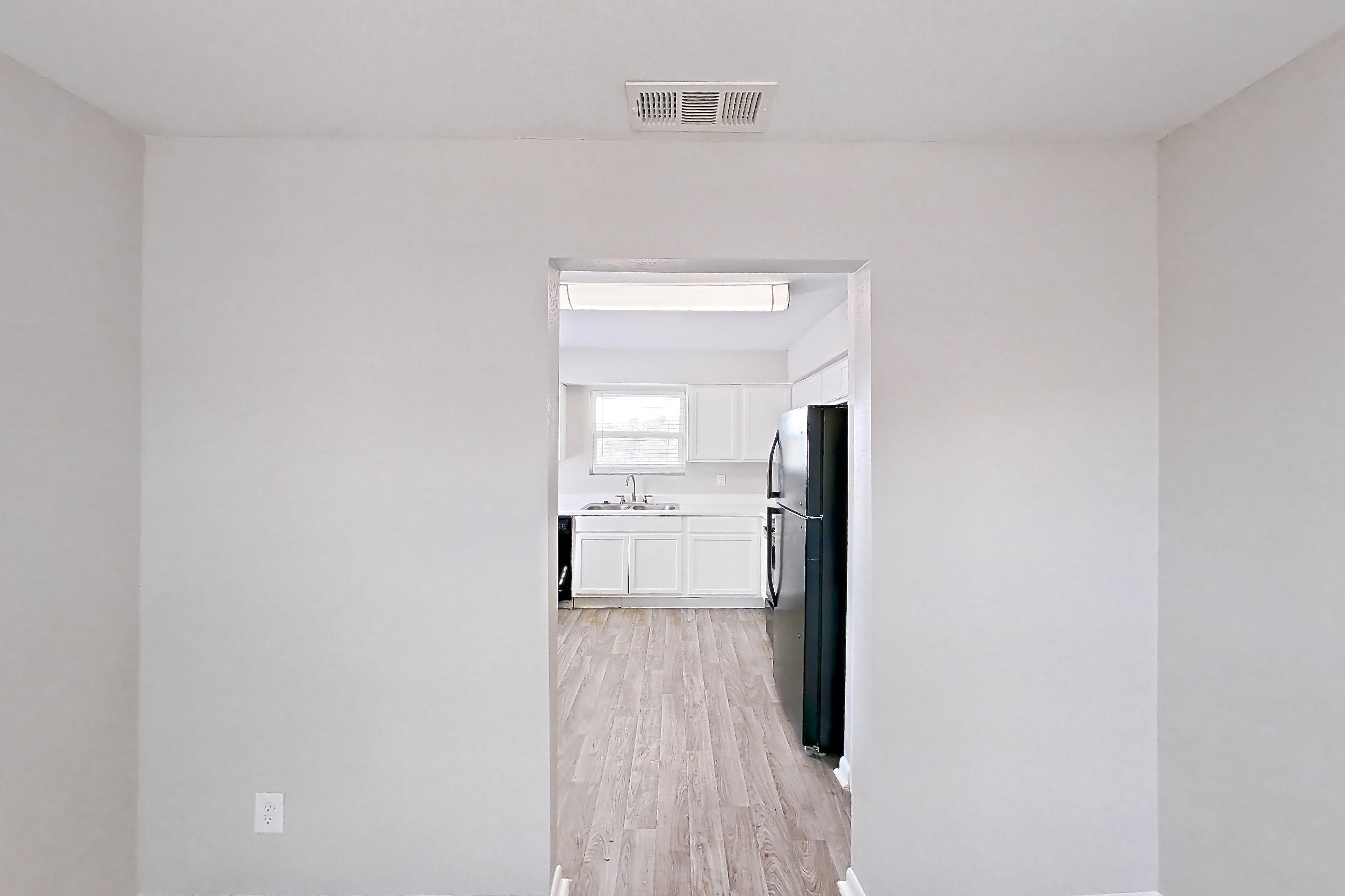 Dining room with black appliances, light wood-finish flooring, and refrigerator, Apartment 2902 at Bella Vista