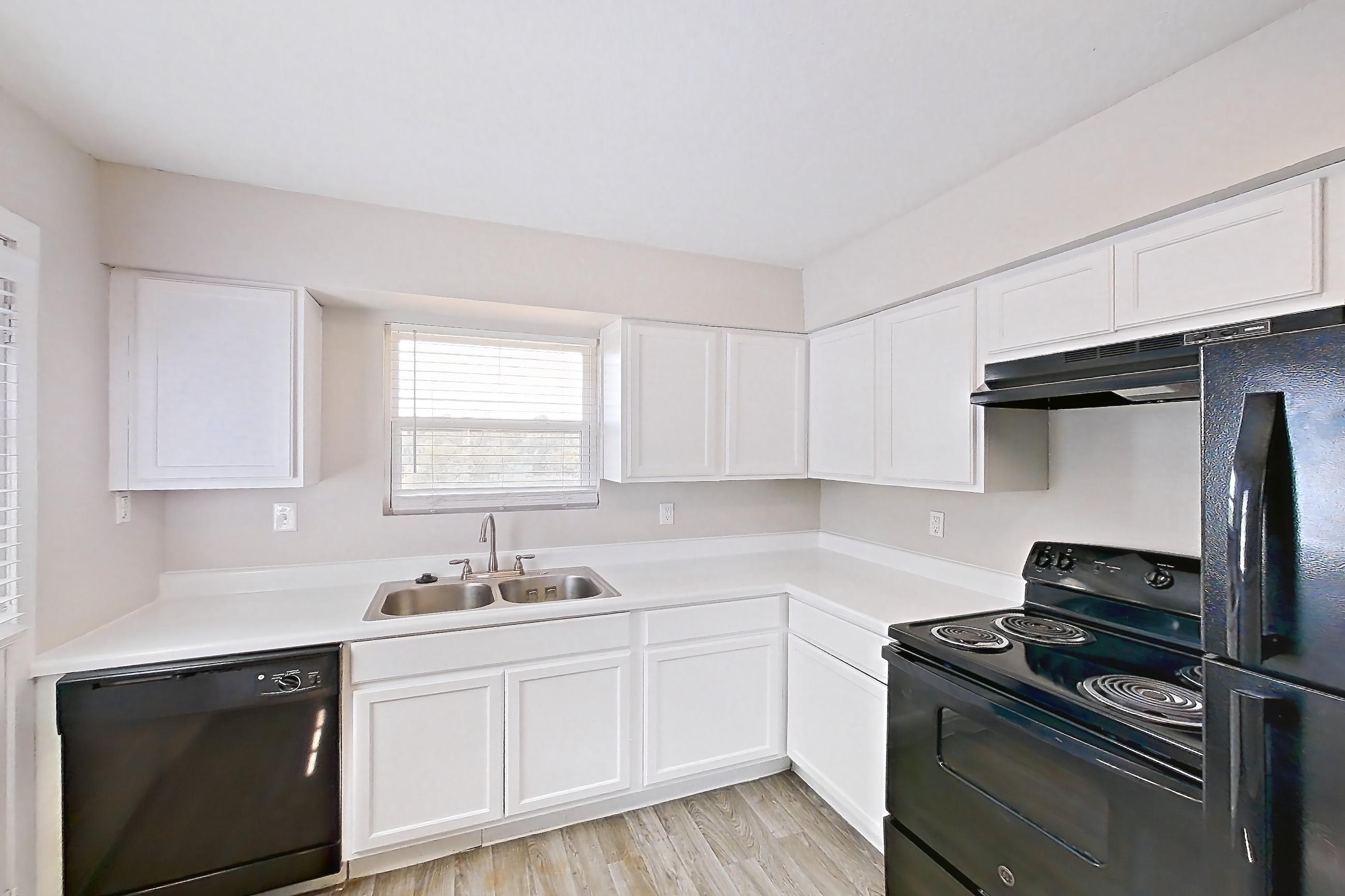 Kitchen with black appliances, dishwasher, electric range, light countertops, light wood-finish flooring, oven/range, and refrigerator, Apartment 2902 at Bella Vista