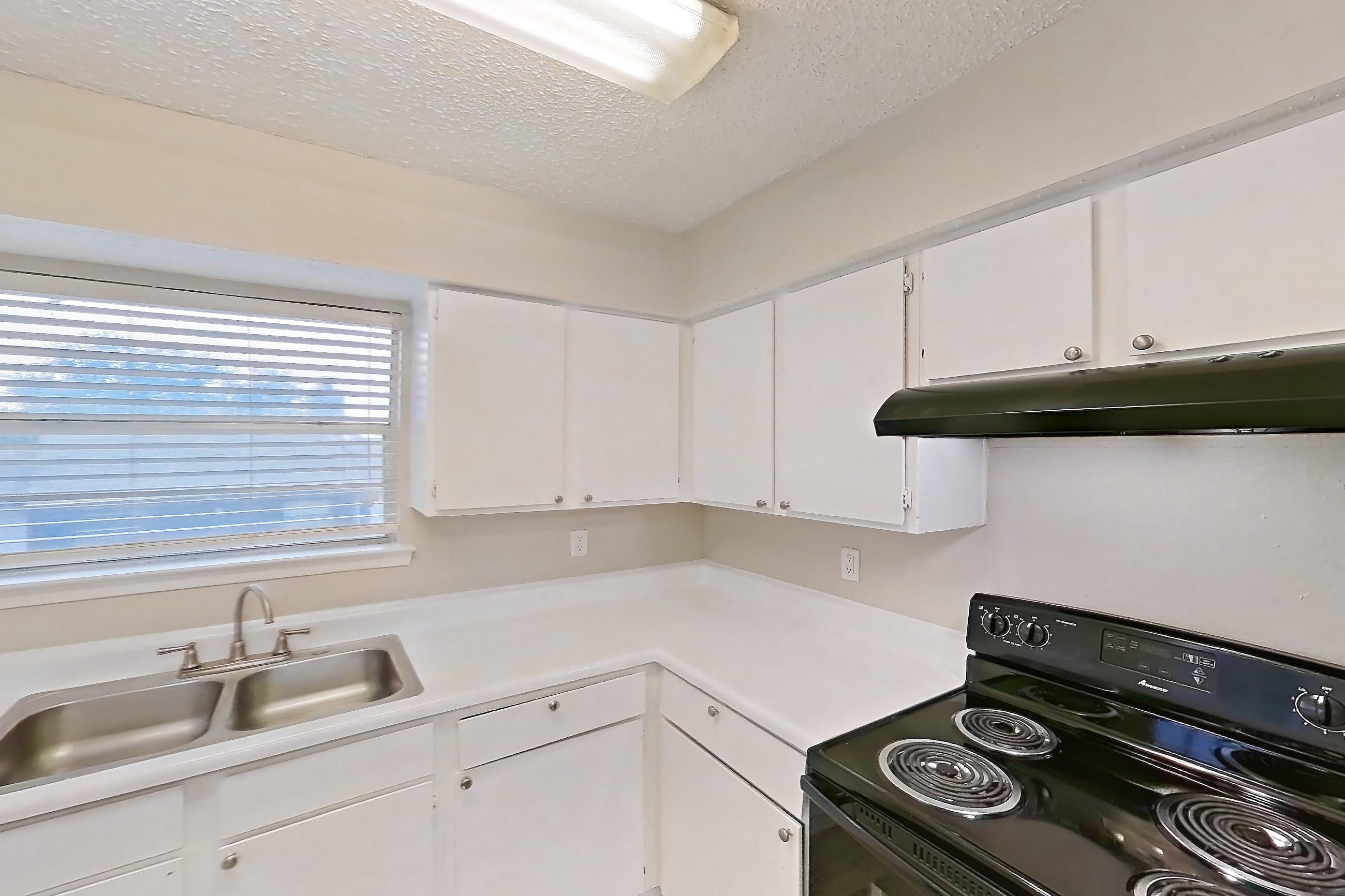 Kitchen with black appliances, dishwasher, electric range, light countertops, light wood-finish flooring, oven/range, and refrigerator, Apartment 4104 at Bella Vista