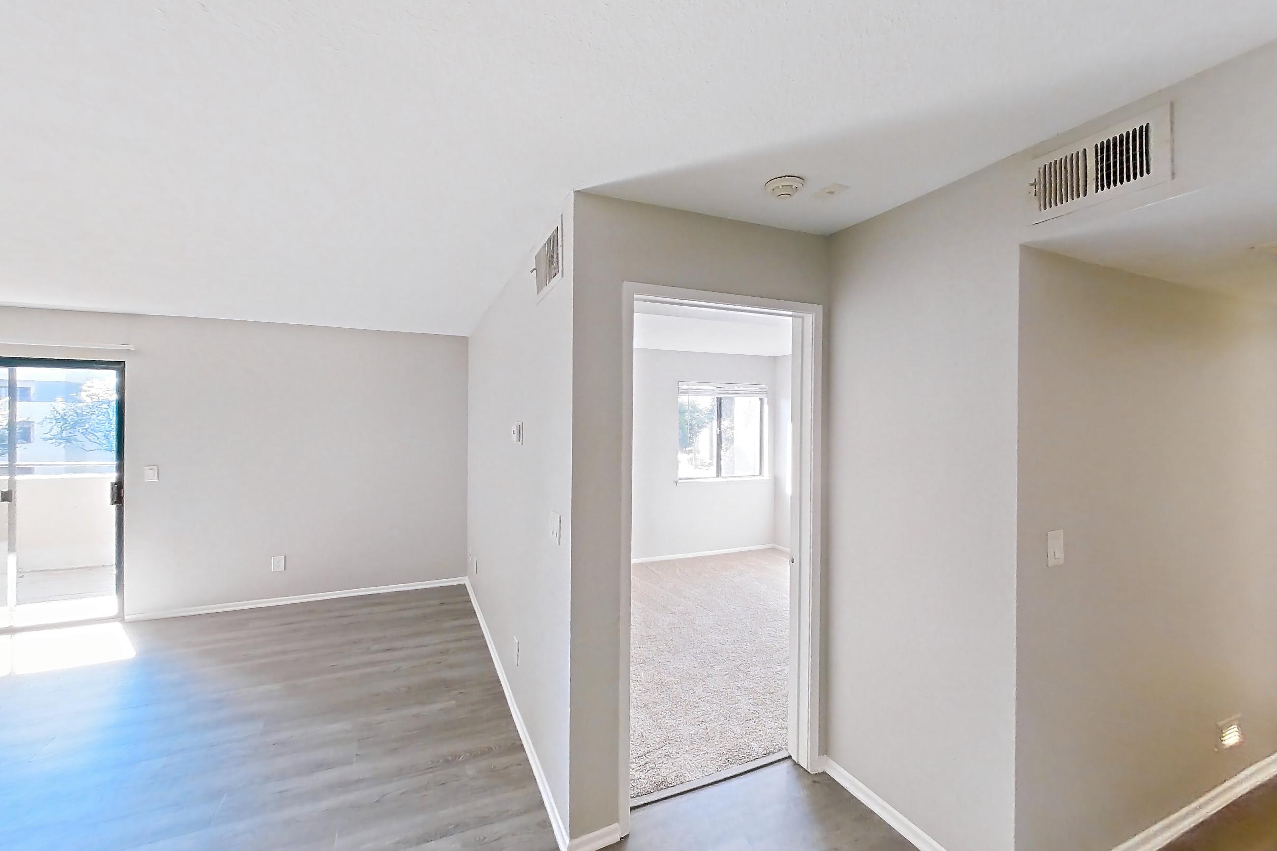 Dining room with in-unit laundry, light stone countertops, light wood-finish flooring, oven/range, refrigerator, and stainless steel appliances, Apartment Y-05 at Avana Rancho Cucamonga