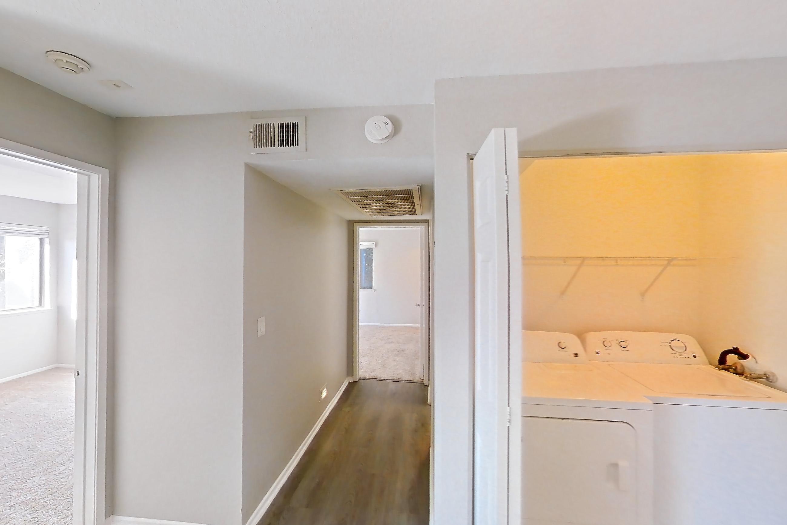 Dining room with in-unit laundry, light stone countertops, light wood-finish flooring, oven/range, refrigerator, and stainless steel appliances, Apartment Y-05 at Avana Rancho Cucamonga