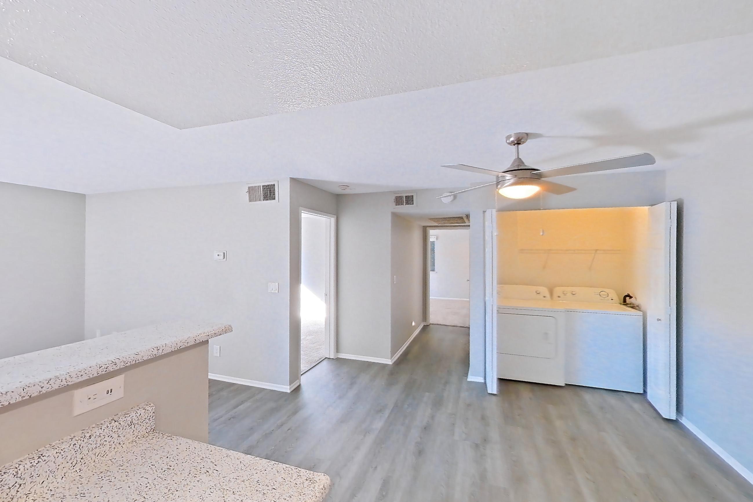 Kitchen with dishwasher, in-unit laundry, light stone countertops, light wood-finish flooring, microwave, oven/range, and stainless steel appliances, Apartment Y-05 at Avana Rancho Cucamonga