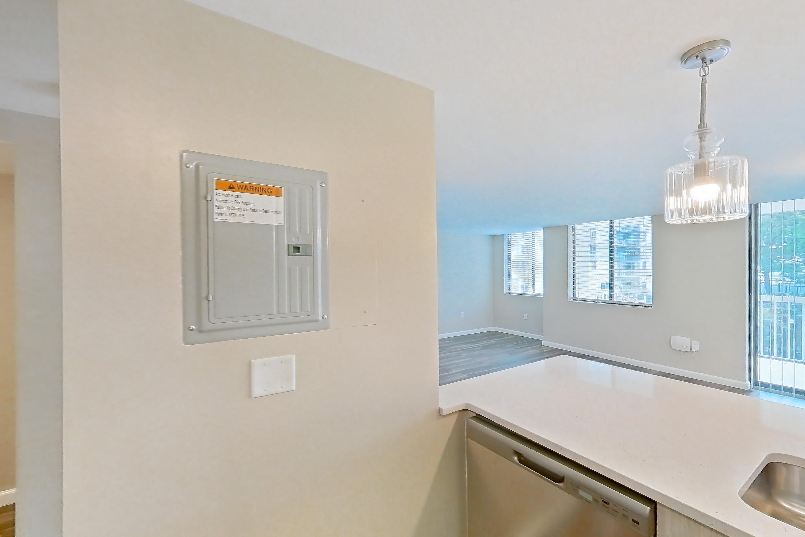 Kitchen with dishwasher, electric range, light countertops, light stone countertops, light wood-finish flooring, microwave, oven/range, refrigerator, and stainless steel appliances, Apartment 219 at Cortland at McLean