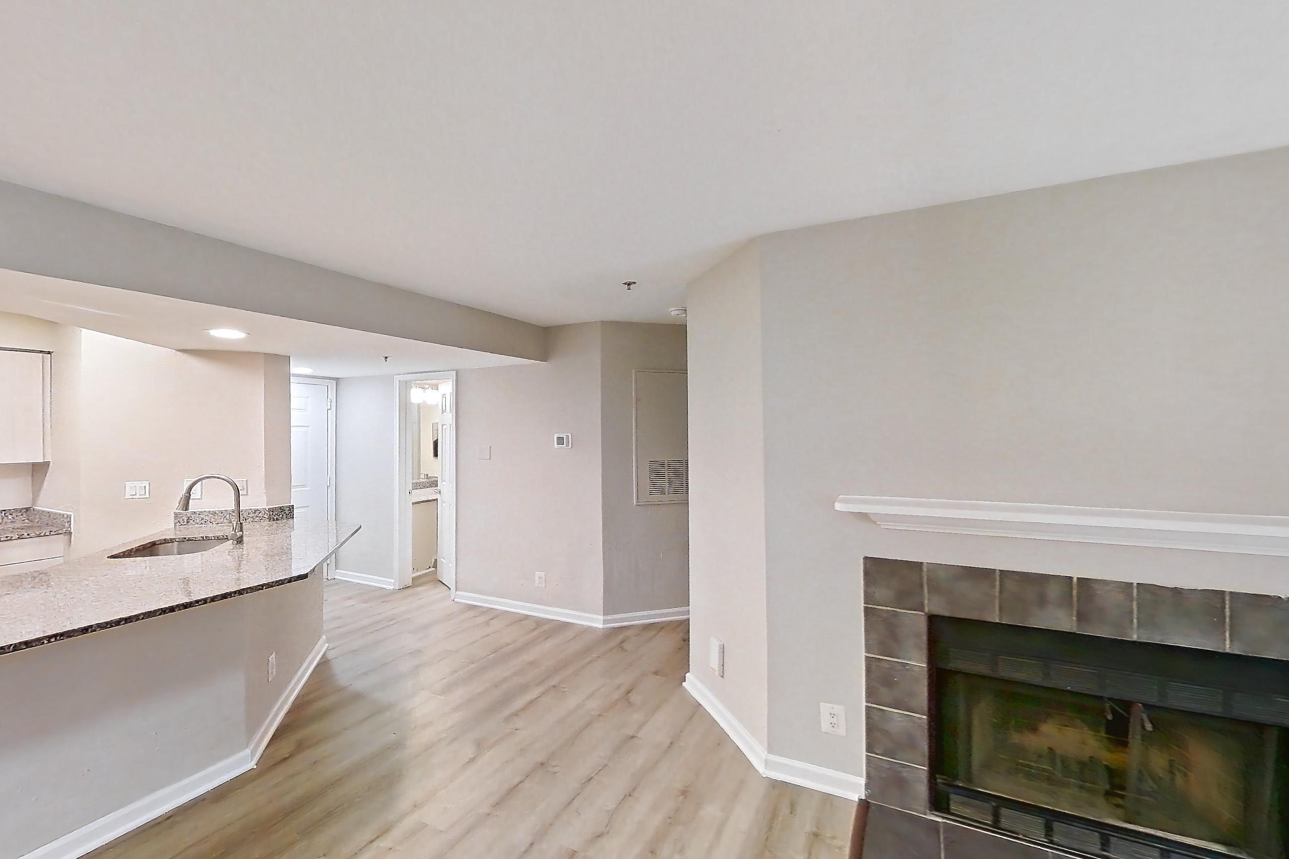 Living room with fireplace, light wood-finish flooring, and tile fireplace, Apartment 1101 at Cortland Van Dorn