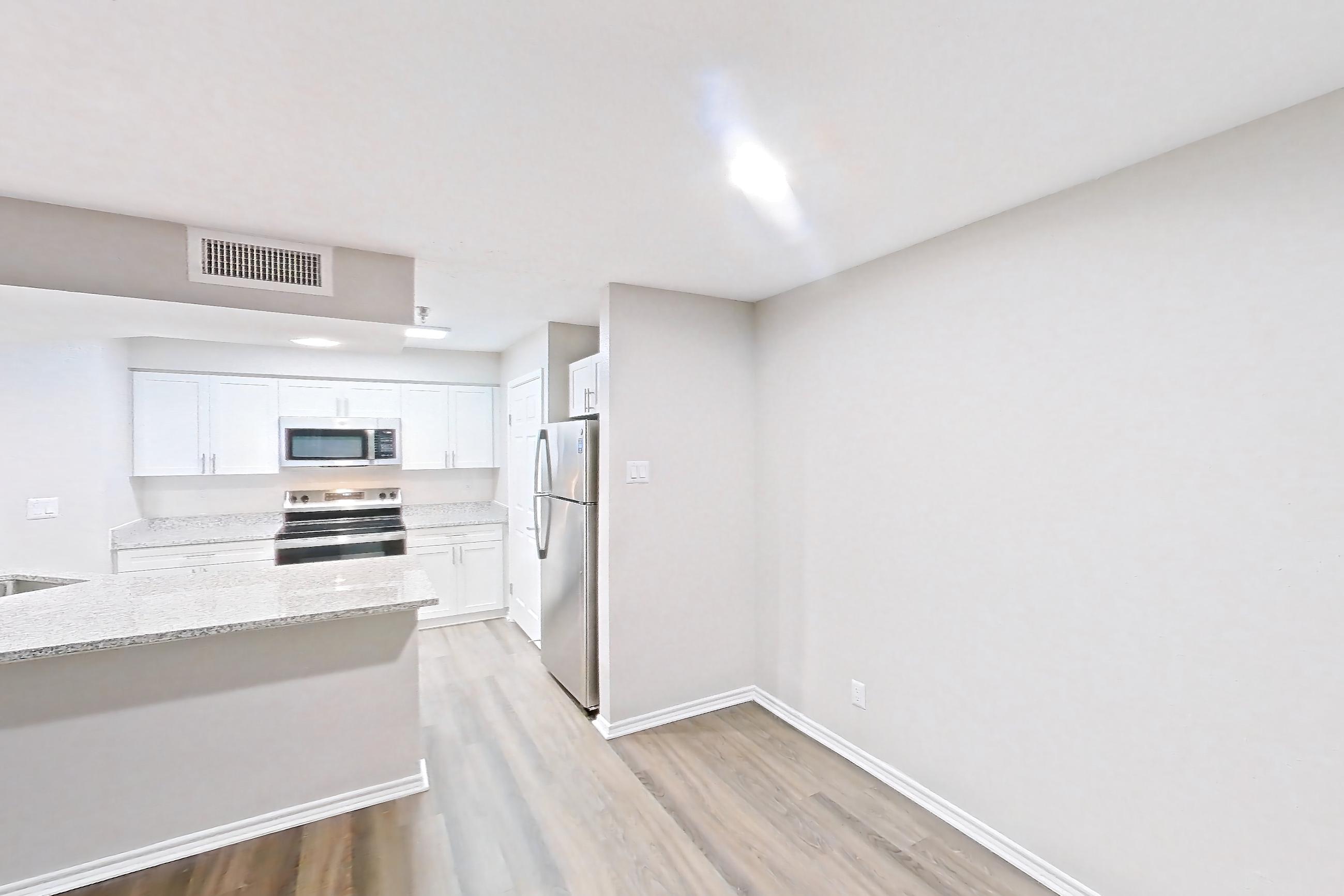 Living room with dark wood-finish flooring, electric range, kitchen island, light stone countertops, light wood-finish flooring, oven/range, refrigerator, and stainless steel appliances, Apartment 3110 at Cortland Van Dorn