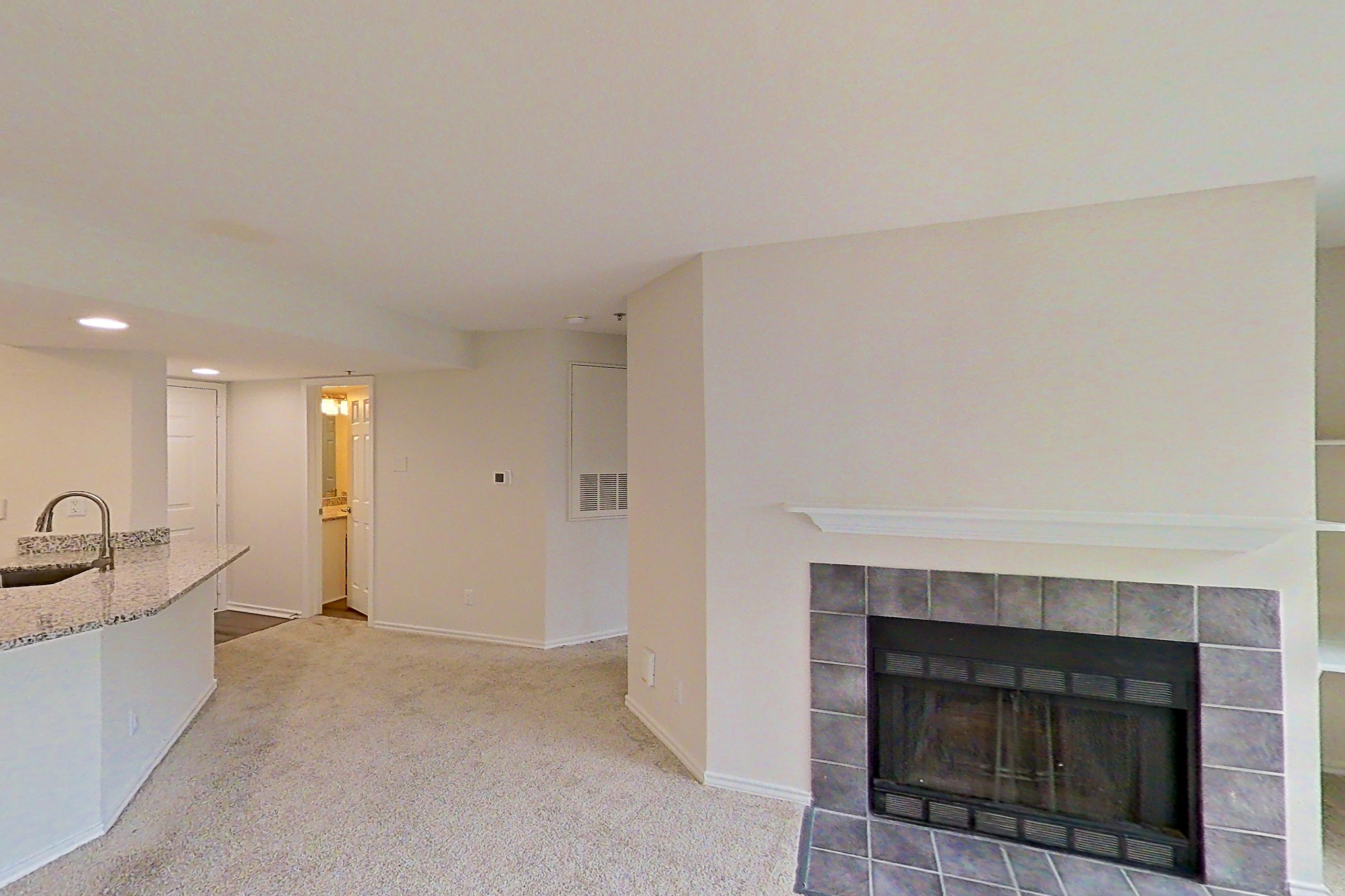 Living room with fireplace, light carpet, and tile fireplace, Apartment 5117 at Cortland Van Dorn
