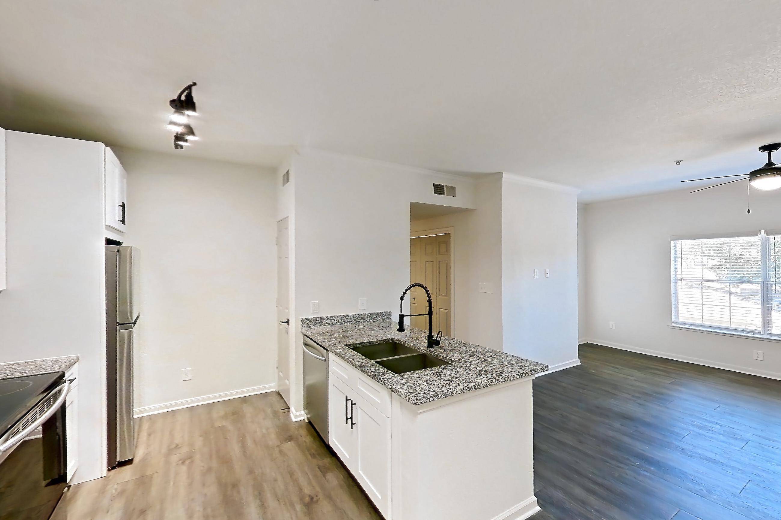 Dining room with dark wood-finish flooring, dishwasher, electric range, light stone countertops, light wood-finish flooring, oven/range, refrigerator, and stainless steel appliances, Apartment 2206 at Cortland at Twin Creeks