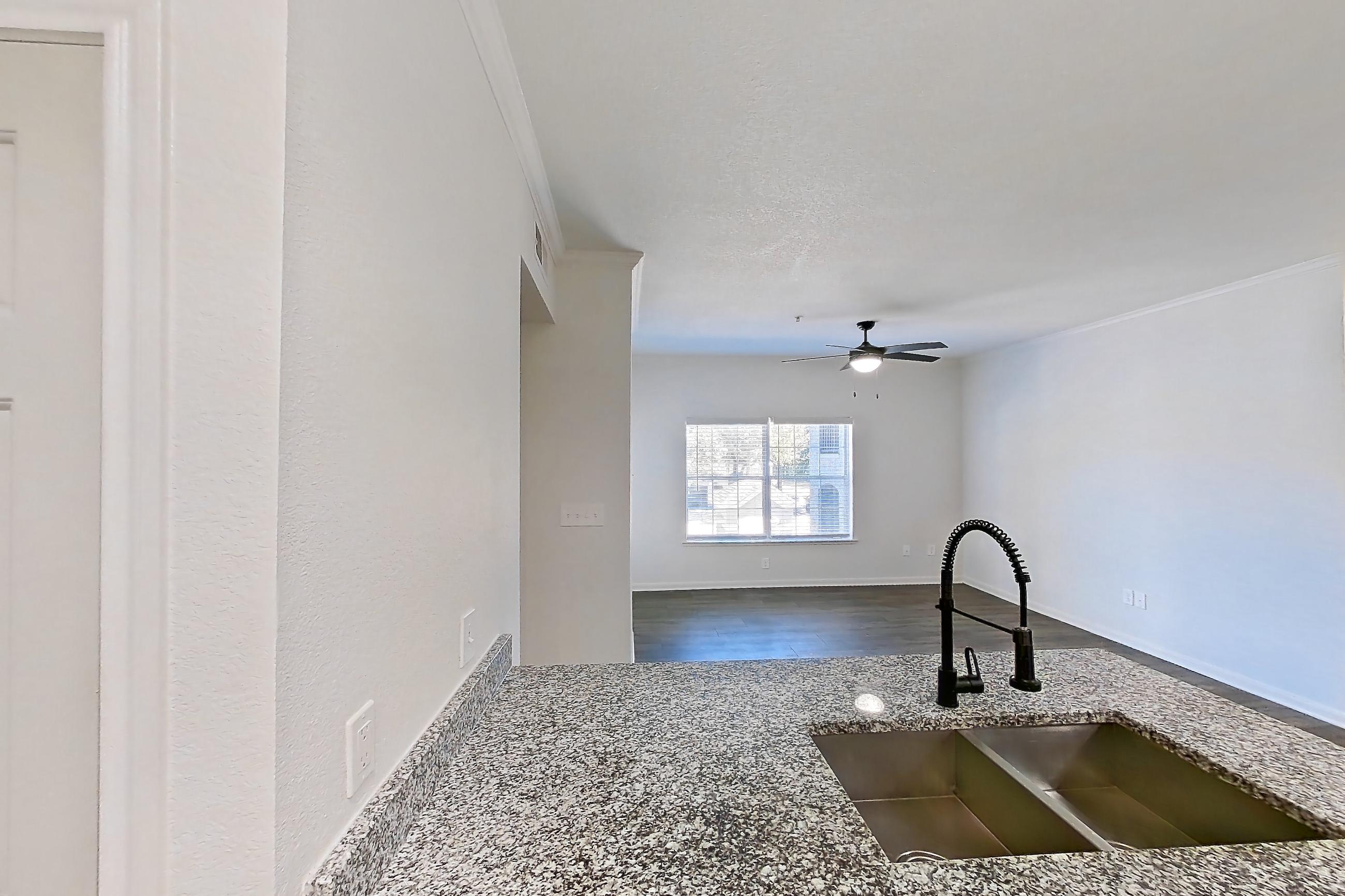 Kitchen with dishwasher, electric range, light stone countertops, light wood-finish flooring, oven/range, and stainless steel appliances, Apartment 2206 at Cortland at Twin Creeks