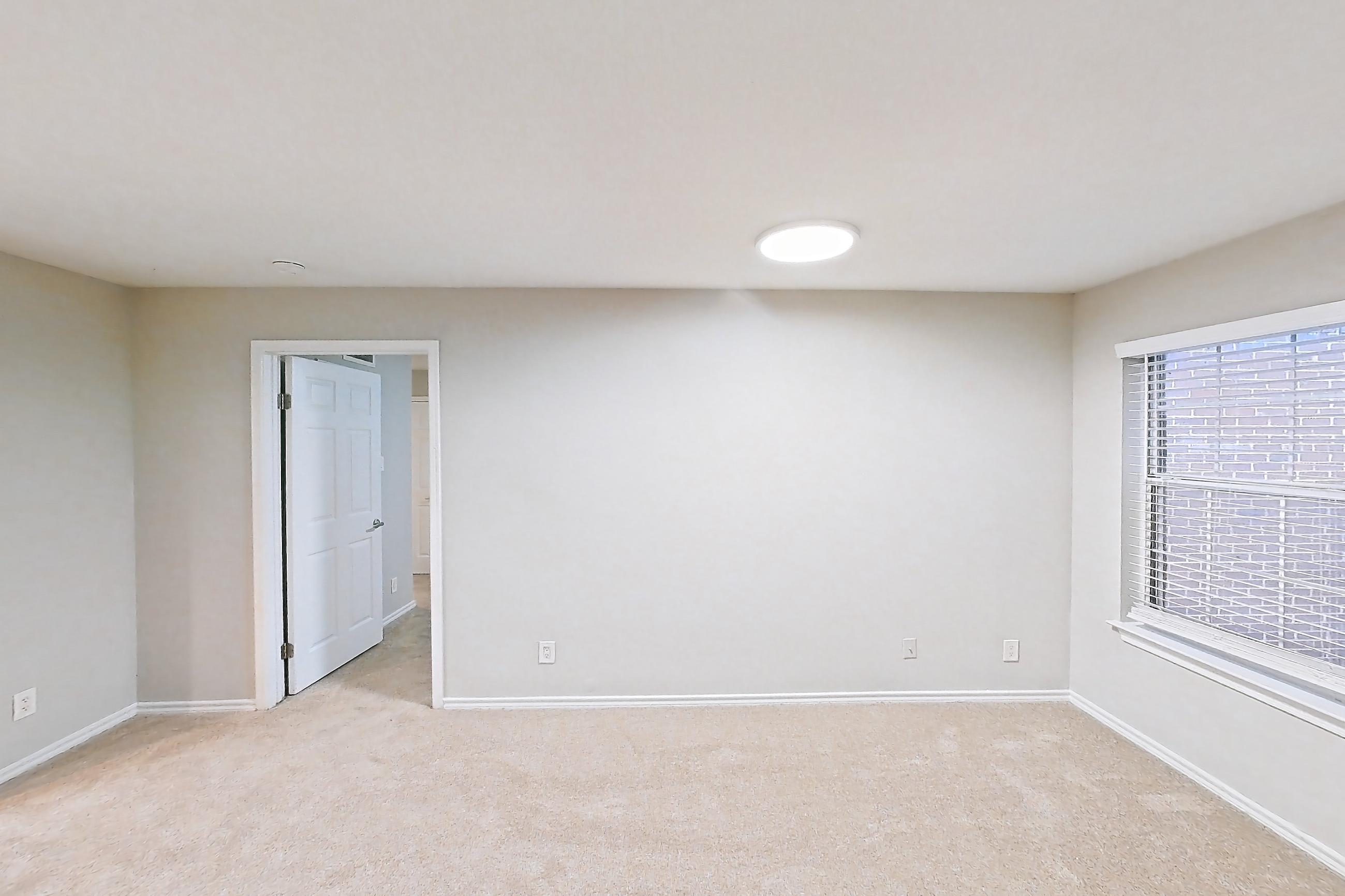 Living room with fireplace, light carpet, oven/range, refrigerator, stainless steel appliances, and tile fireplace, Apartment 2207 at Cortland Van Dorn