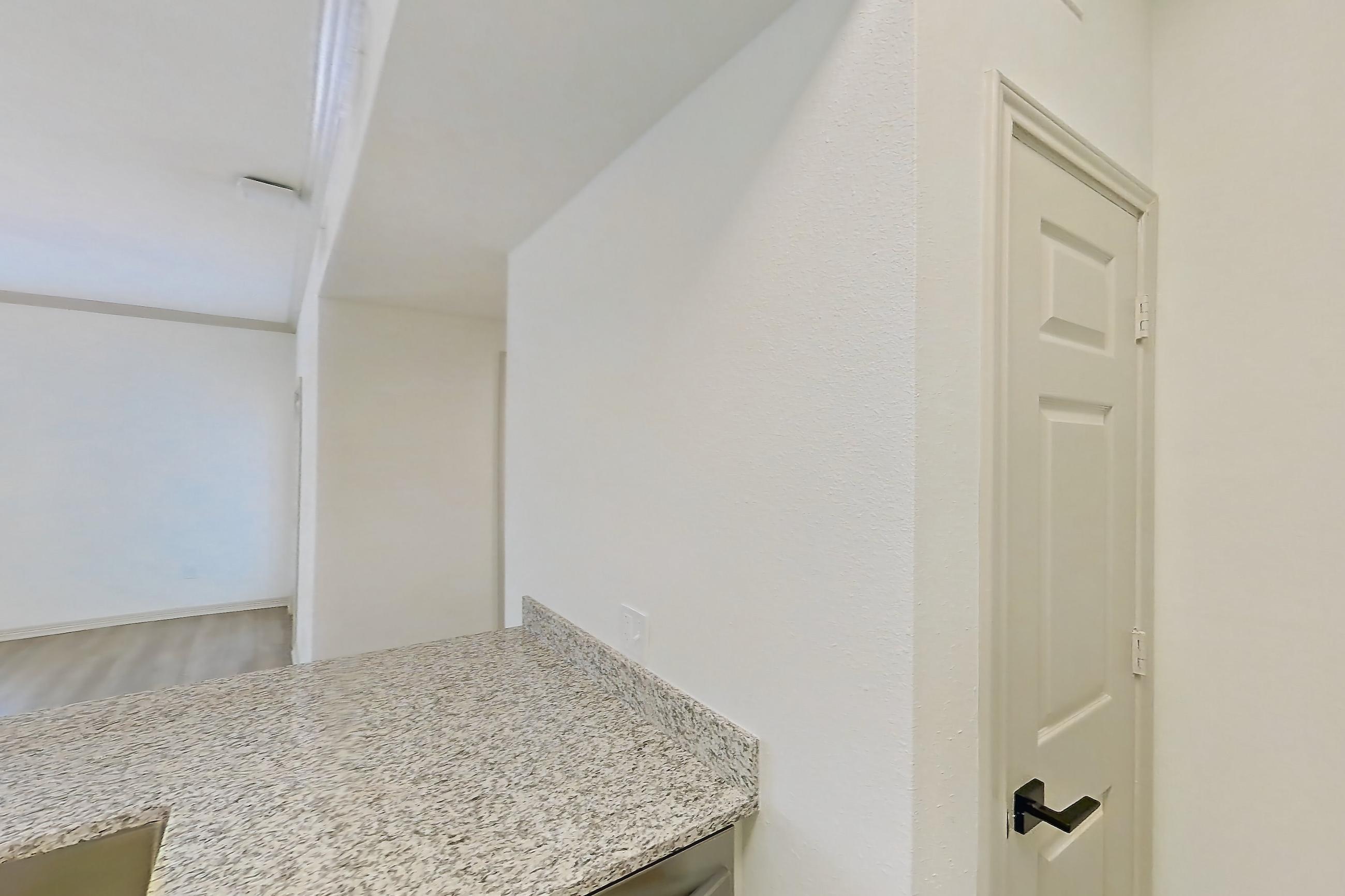 Kitchen with dishwasher, electric range, light countertops, light stone countertops, light wood-finish flooring, microwave, oven/range, stainless steel appliances, and white appliances, Apartment 5209 at Cortland Wortham