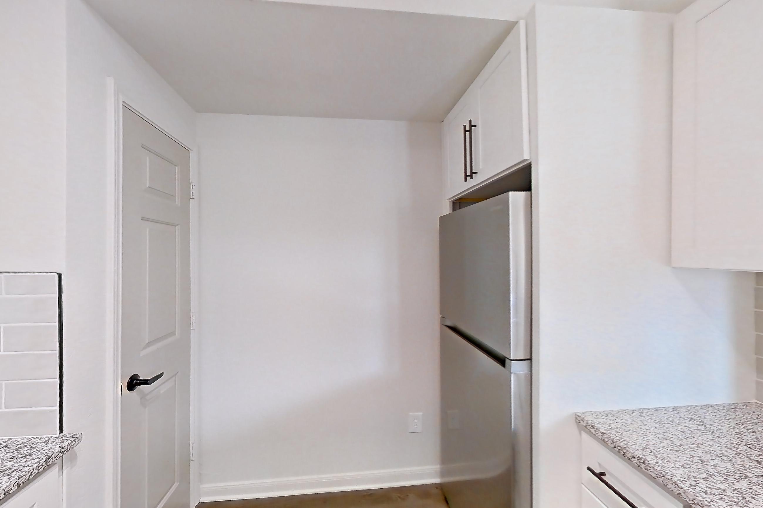 Kitchen with dark wood-finish flooring, dishwasher, electric range, light countertops, light stone countertops, light wood-finish flooring, oven/range, refrigerator, and stainless steel appliances, Apartment 2304 at Cortland at Twin Creeks