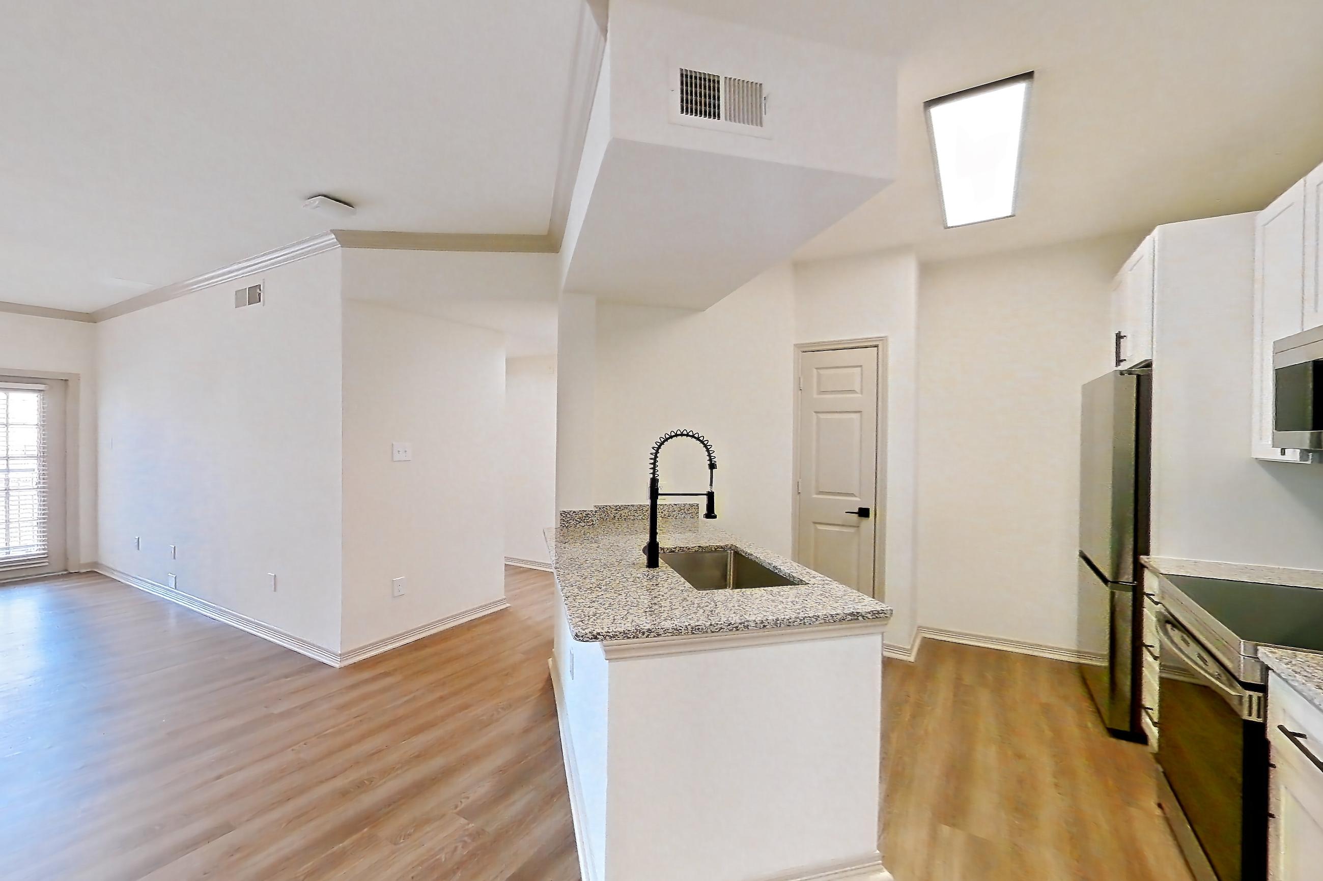 Dining room with electric range, light stone countertops, light wood-finish flooring, microwave, refrigerator, and stainless steel appliances, Apartment 17210 at Cortland Wortham