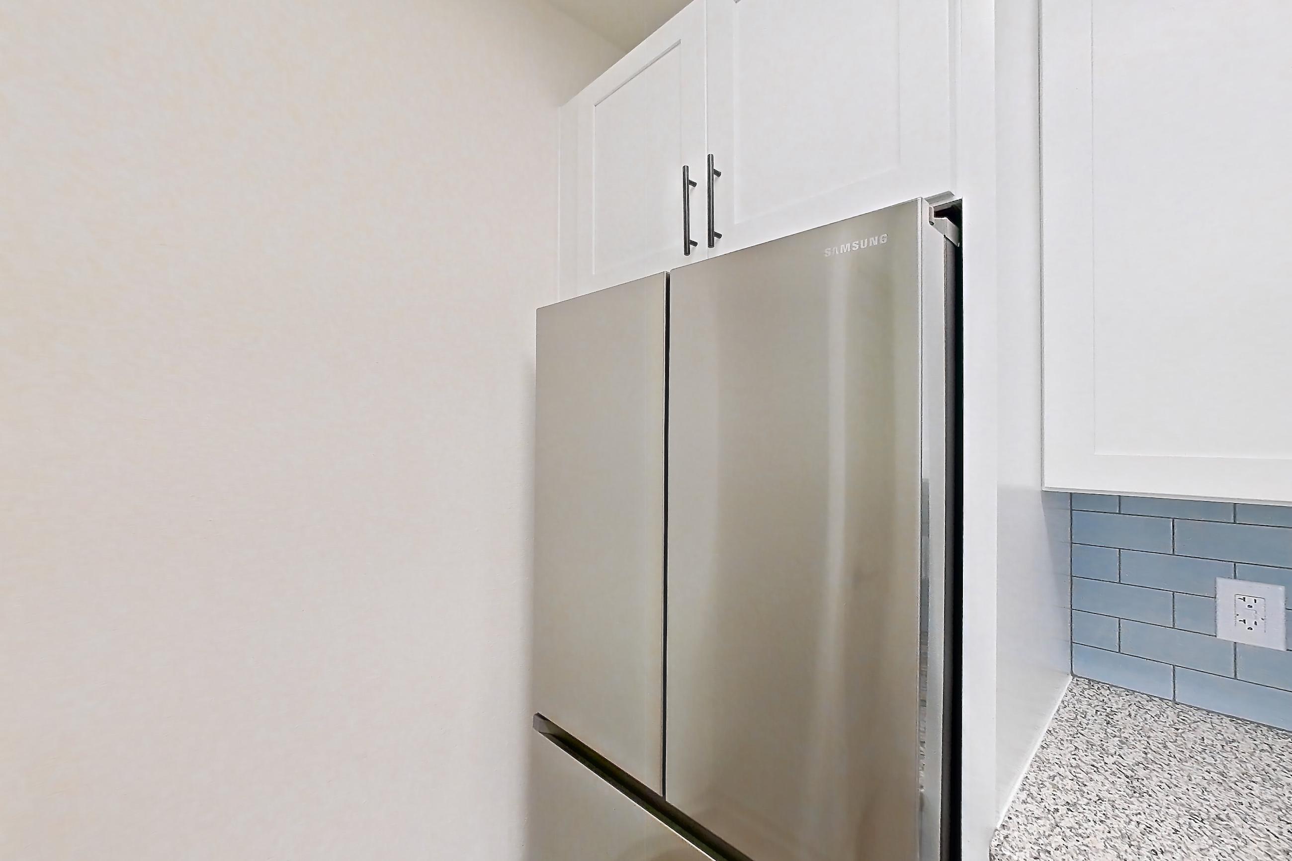 Kitchen with dishwasher, electric range, light countertops, light stone countertops, light wood-finish flooring, microwave, oven/range, and stainless steel appliances, Apartment 17210 at Cortland Wortham