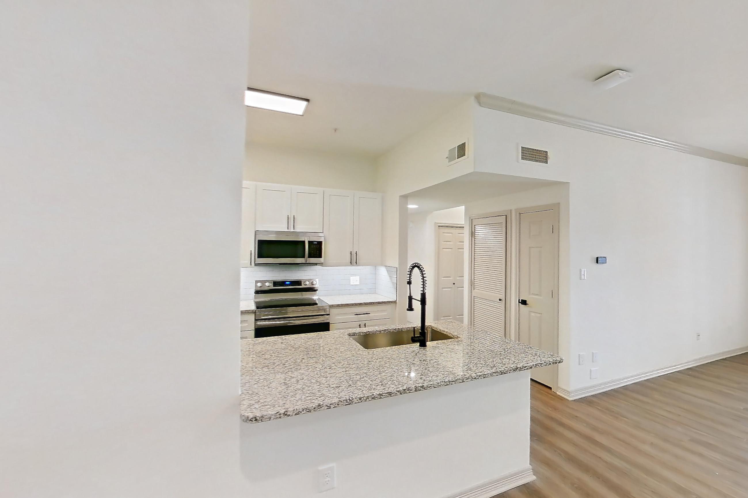 Dining room with electric range, light stone countertops, light wood-finish flooring, oven/range, and stainless steel appliances, Apartment 8305 at Cortland Wortham