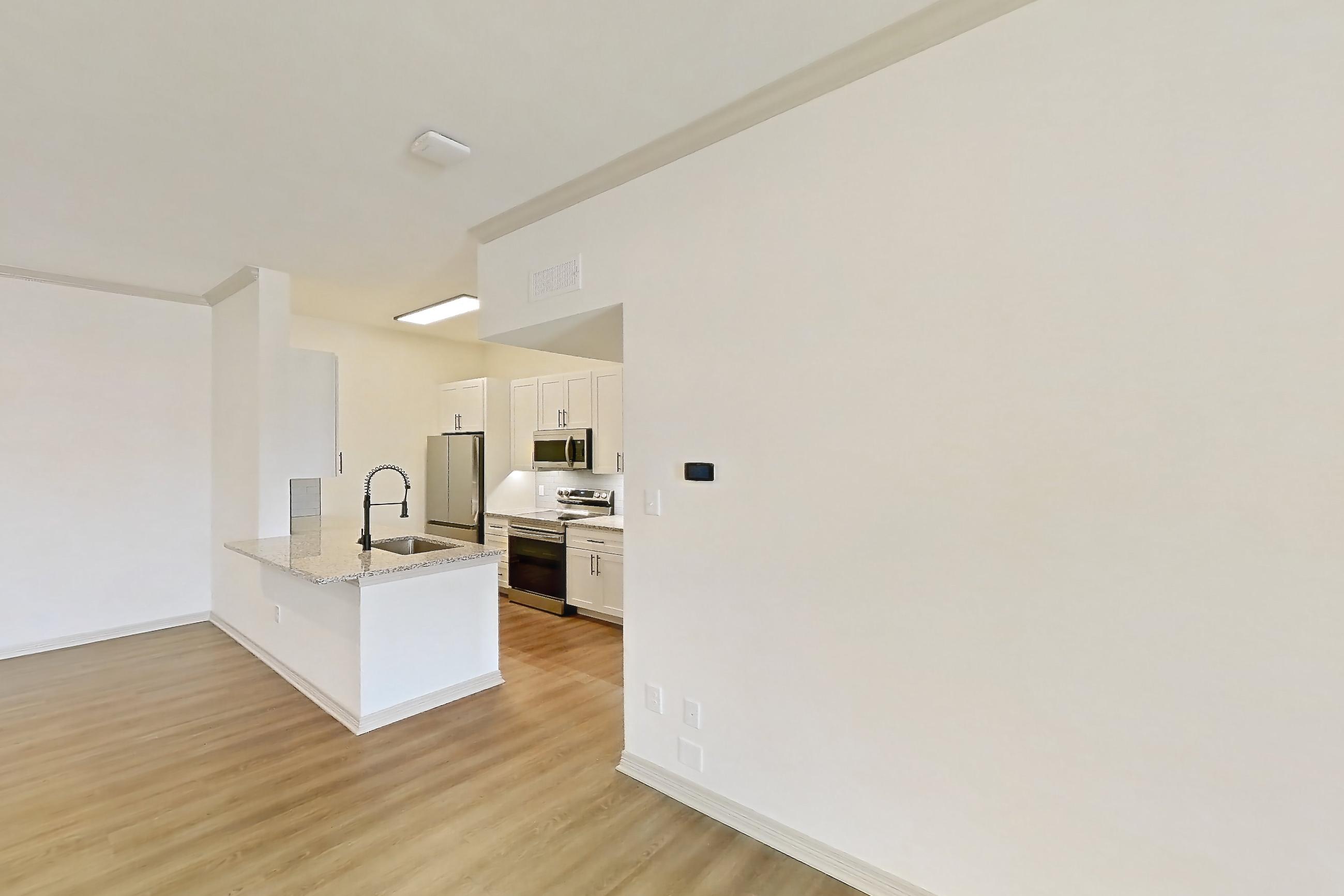 Living room with electric range, light wood-finish flooring, oven/range, and stainless steel appliances, Apartment 8305 at Cortland Wortham