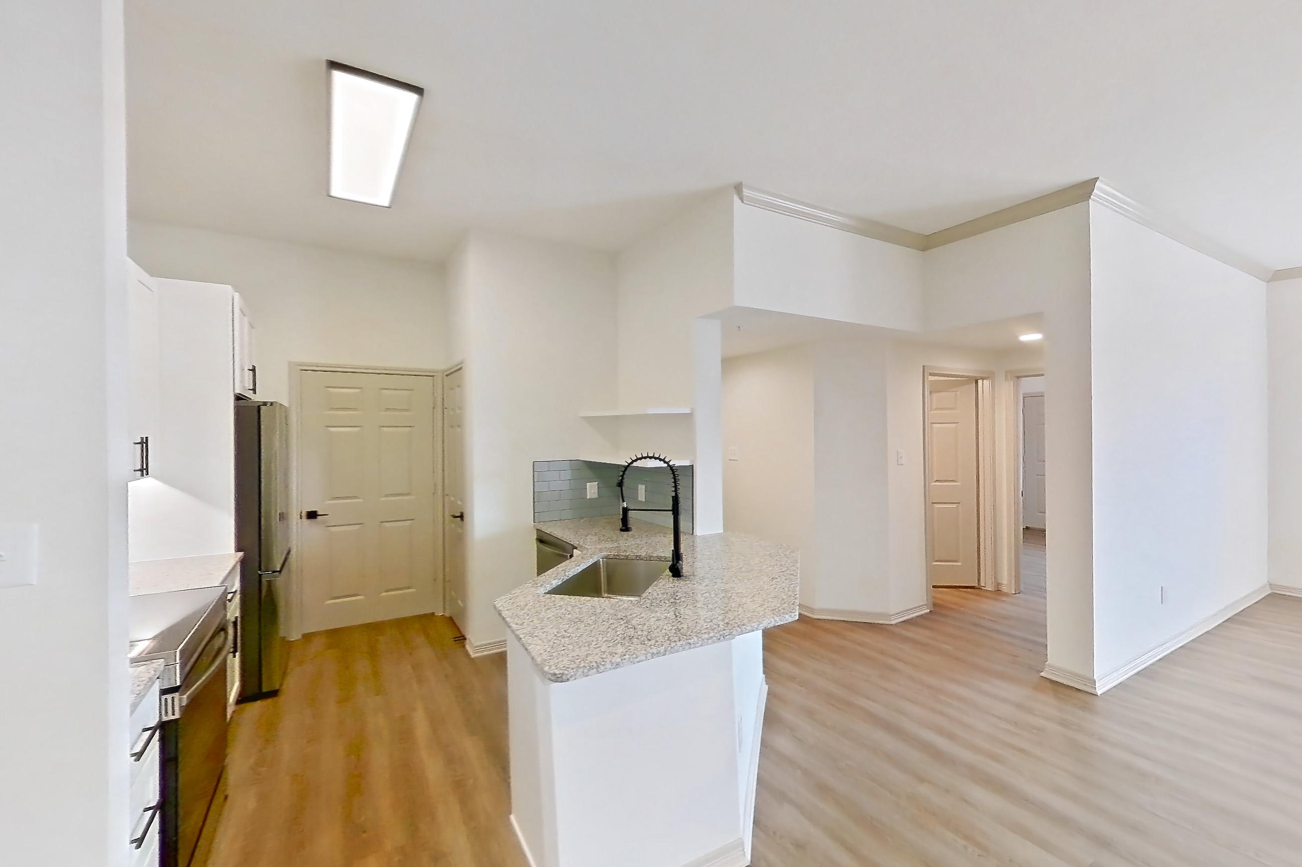 Dining room with electric range, light stone countertops, light wood-finish flooring, oven/range, refrigerator, and stainless steel appliances, Apartment 2306 at Cortland Wortham